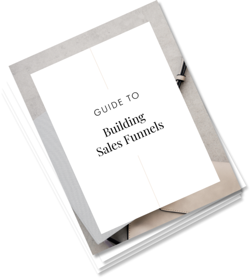 Open notebook with a cover page titled 'Guide to Building Sales Funnels', surrounded by a pen and colorful papers on a desk.