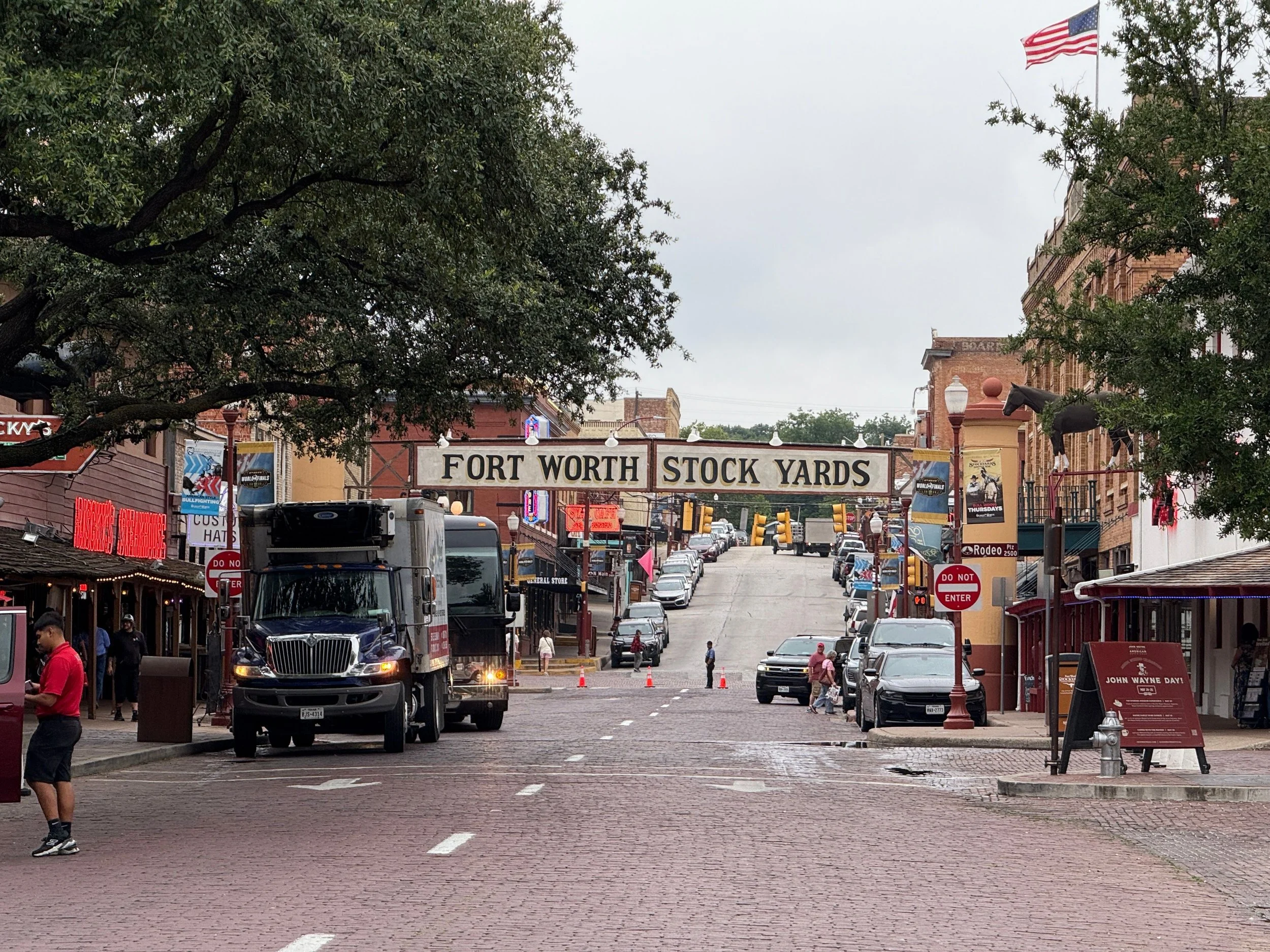 Historic Fort Worth Stockyards brick street and overhead entrance sign in Fort Worth, Texas.