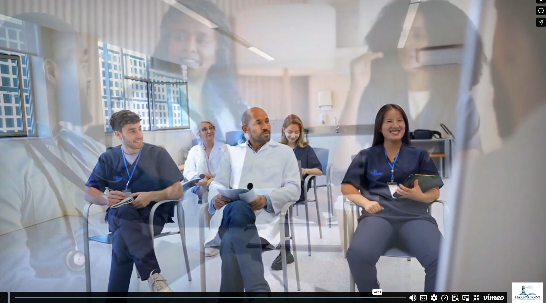 Healthcare professionals, including nurses and doctors, seated in a conference room during a meeting or seminar, viewed through a glass wall or window.