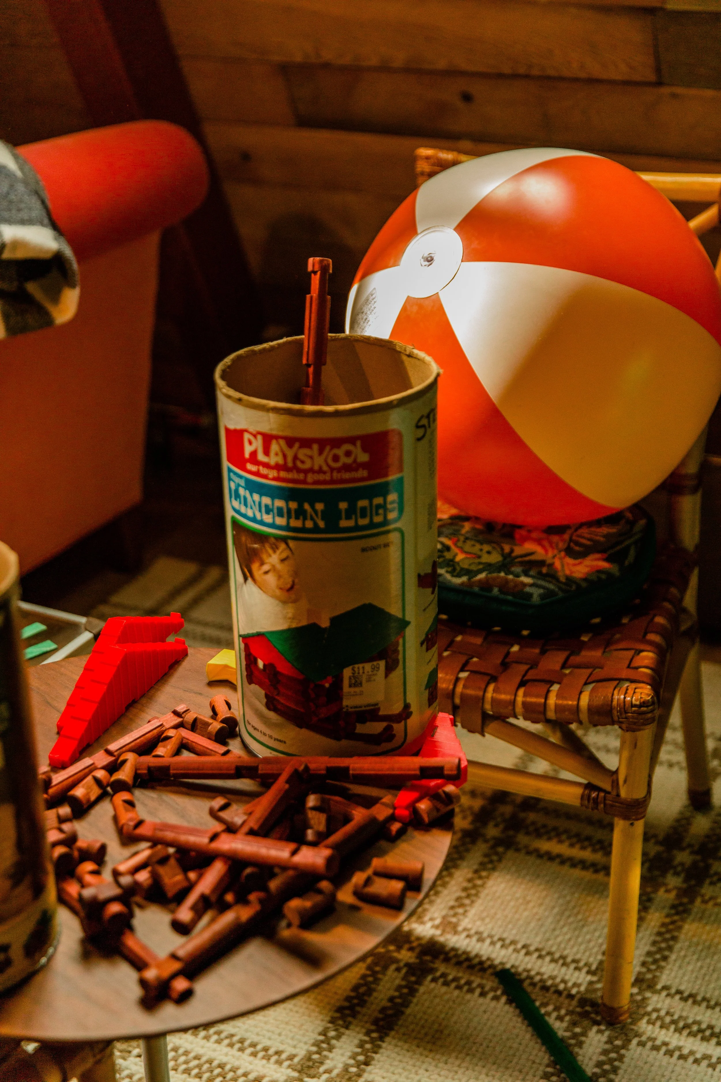 Vintage Lincoln Logs, a striped beach ball, and retro furnishings inside Camp Juniper.