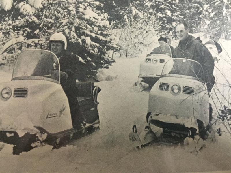 Vintage snowmobile scene in a snowy mountain landscape