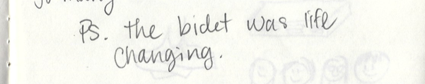 Close-up of handwritten note on paper, mentioning a life-changing bidet.