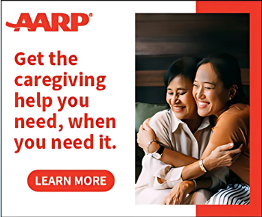Two women smiling and hugging in a cozy indoor setting, with text promoting caregiving support from AARP and a red "Learn More" button.
