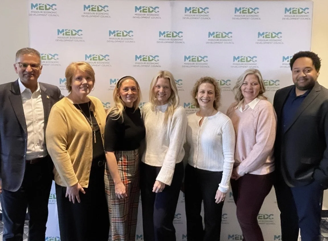 People standing in front of a MEDC-branded wall