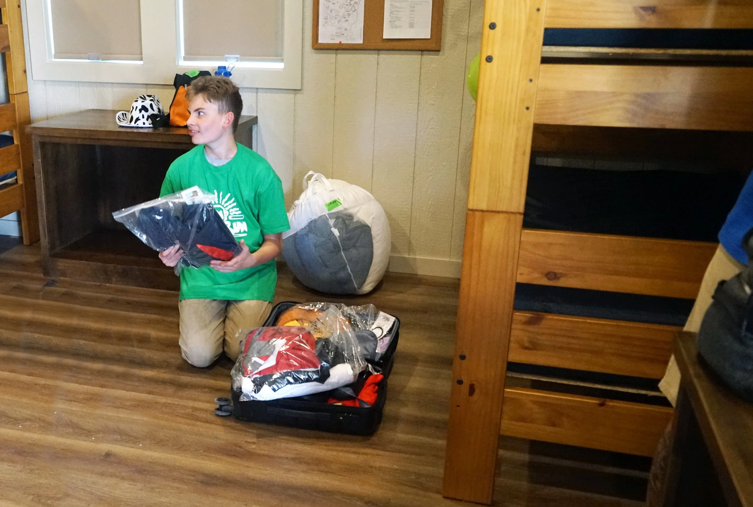 Camper in his bunker unpacking his suitcase at Camp River Run