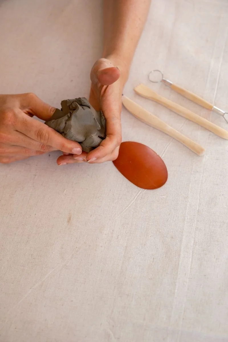 Earthy pottery clay shaped by hands, highlighting three-dimensional tactile expression in an integrative arts psychotherapy session.