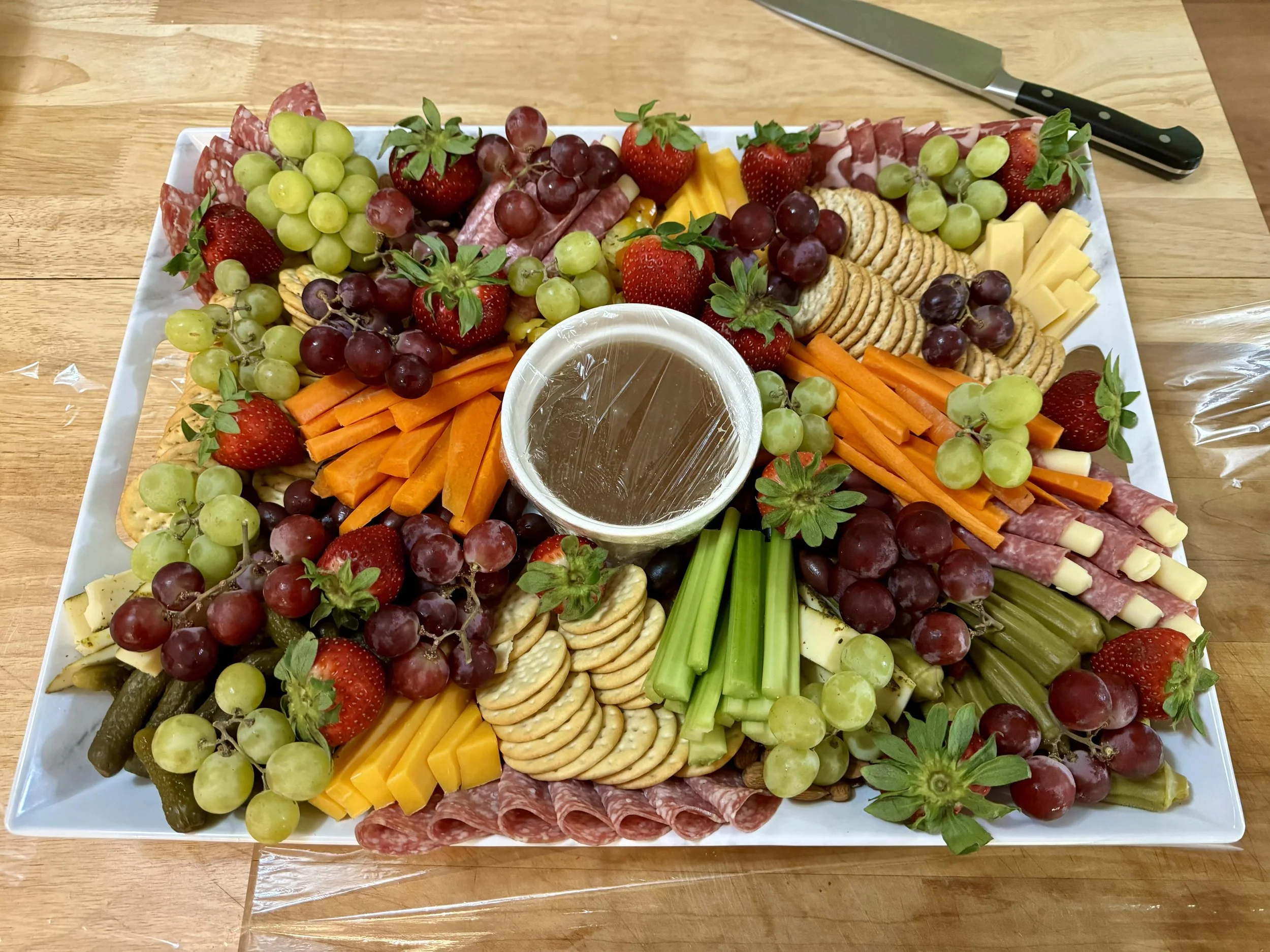 Charcuterie with a variety of cheeses, cured meats, nuts, fruits, and crackers