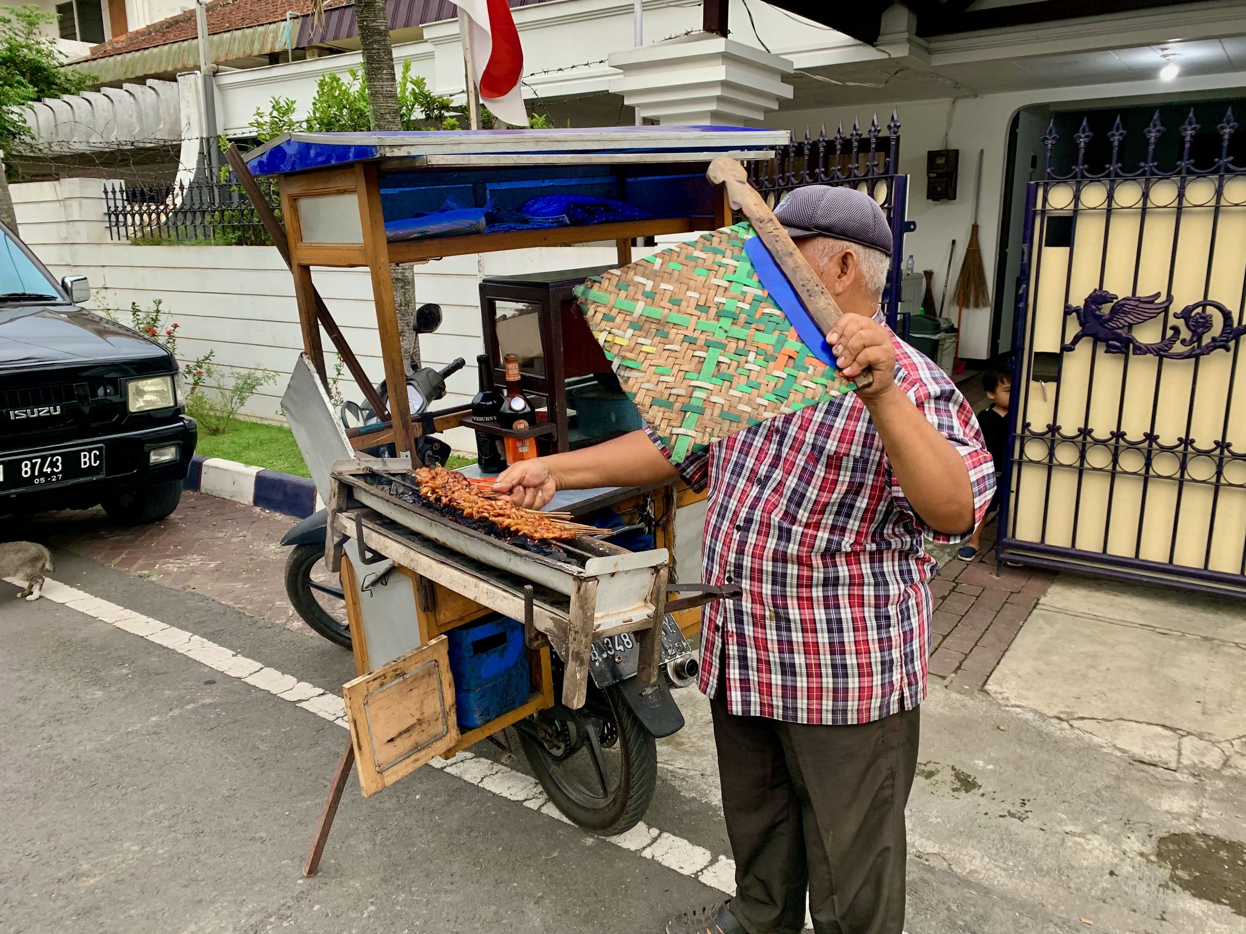 The satay man. He sells satay from the back of a motor bike.