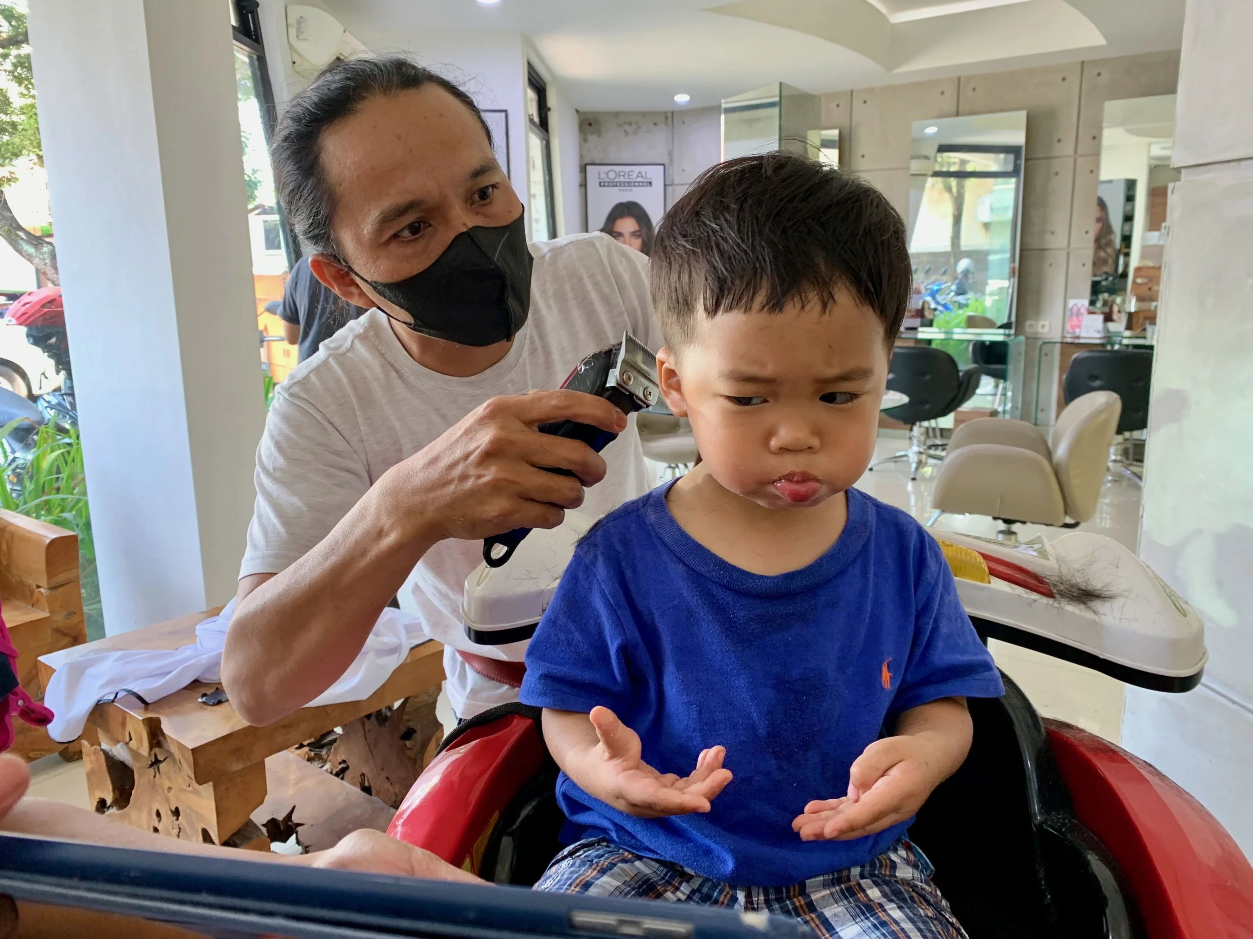 Ethan's not sure about his first professional hair cut