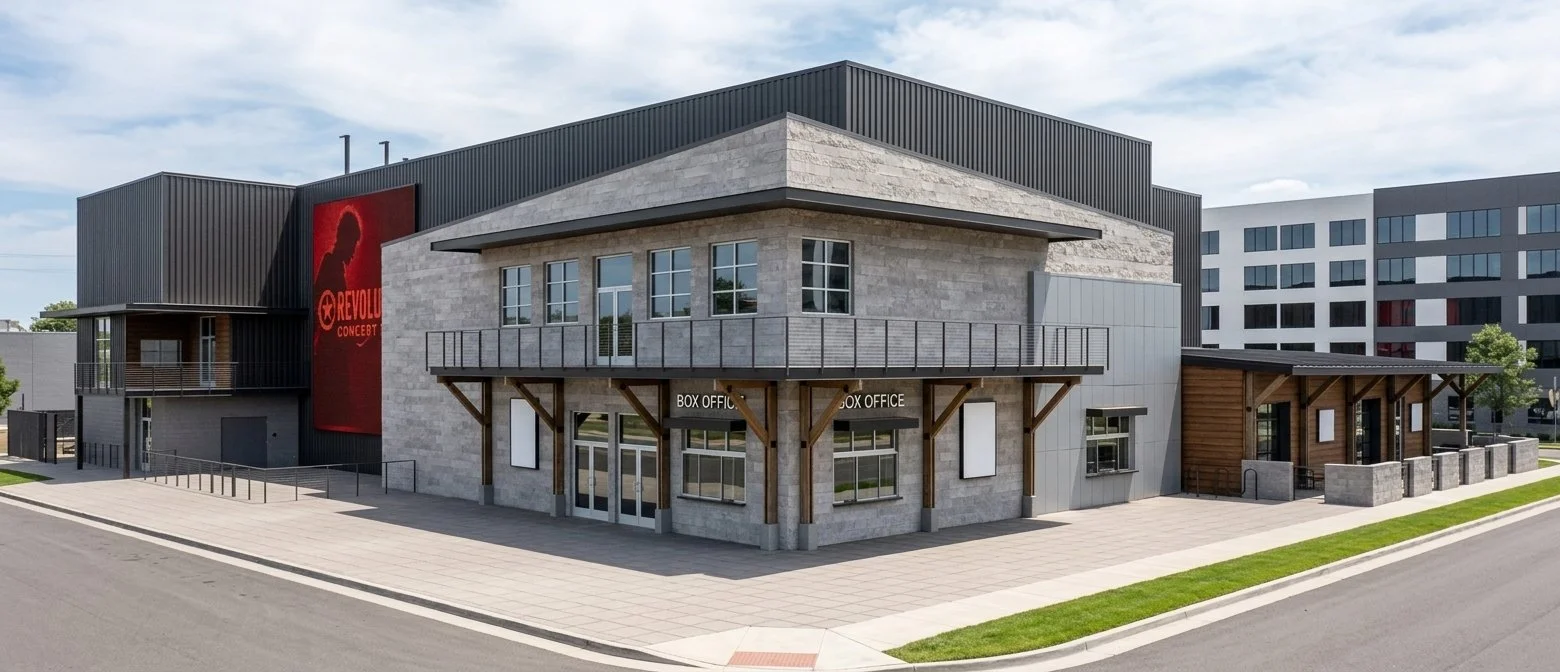 A modern building with a box office entrance, large windows, and a balcony on the second floor. The building features a combination of concrete, metal, and wood exterior materials. There is a prominent red banner on the side with a silhouette of a pe