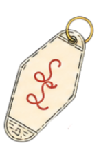 A clothing tag with a red handwritten signature and a gold safety pin attached to it.