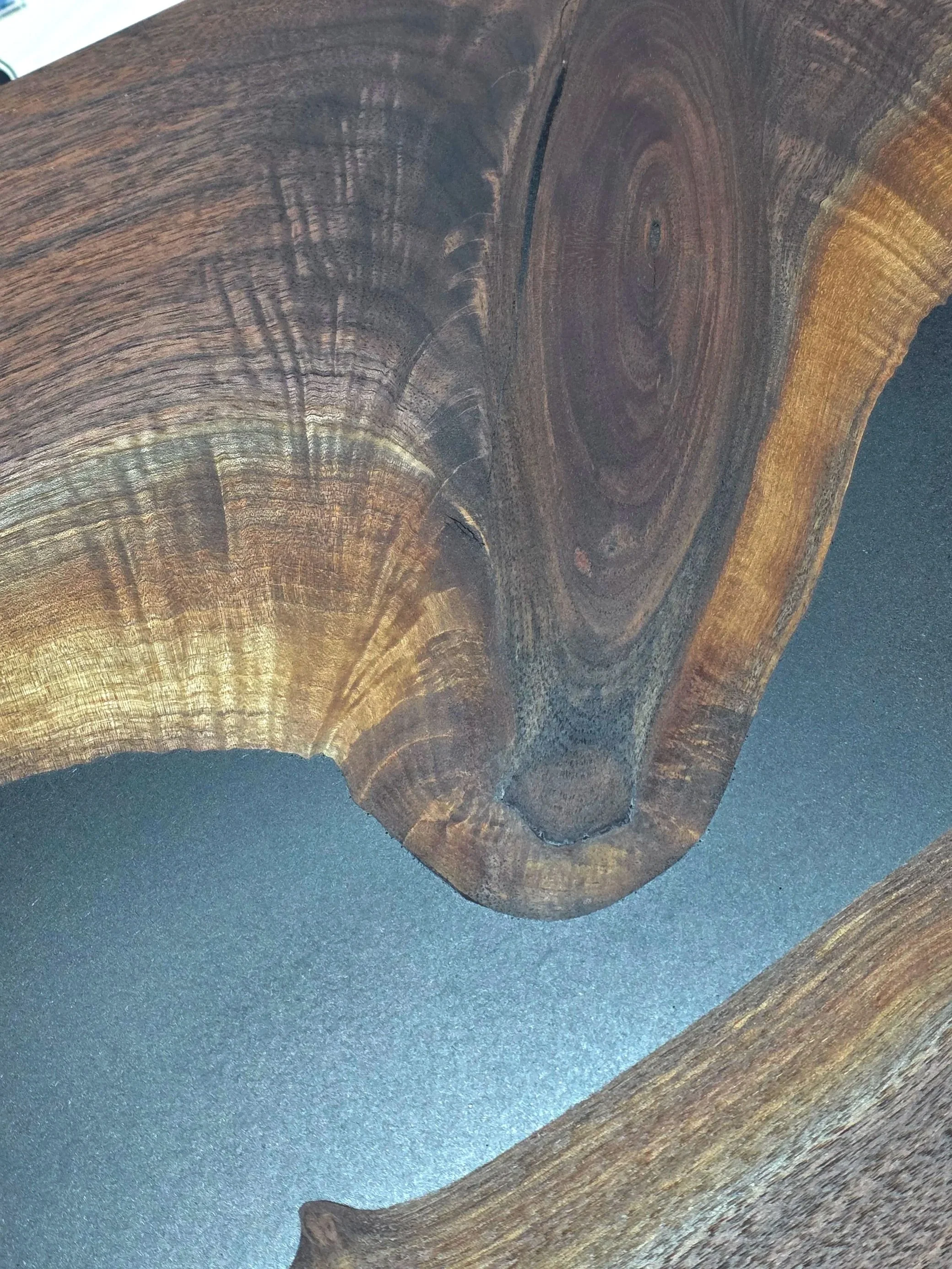 Close-up of a wooden surface with visible wood grain and concentric growth rings.