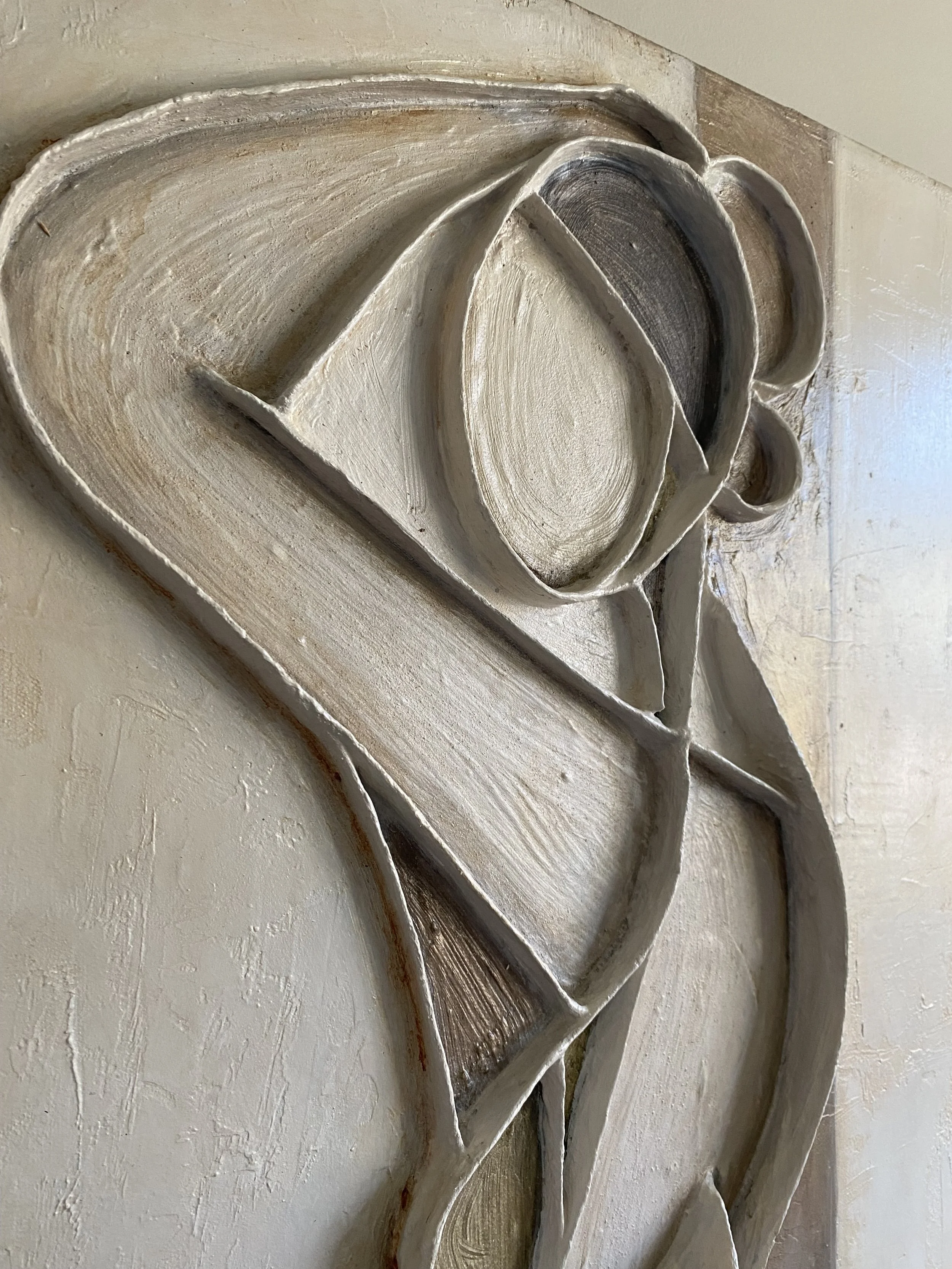 Close-up of an ornate plaster architectural relief with layered scrollwork and curved floral details.