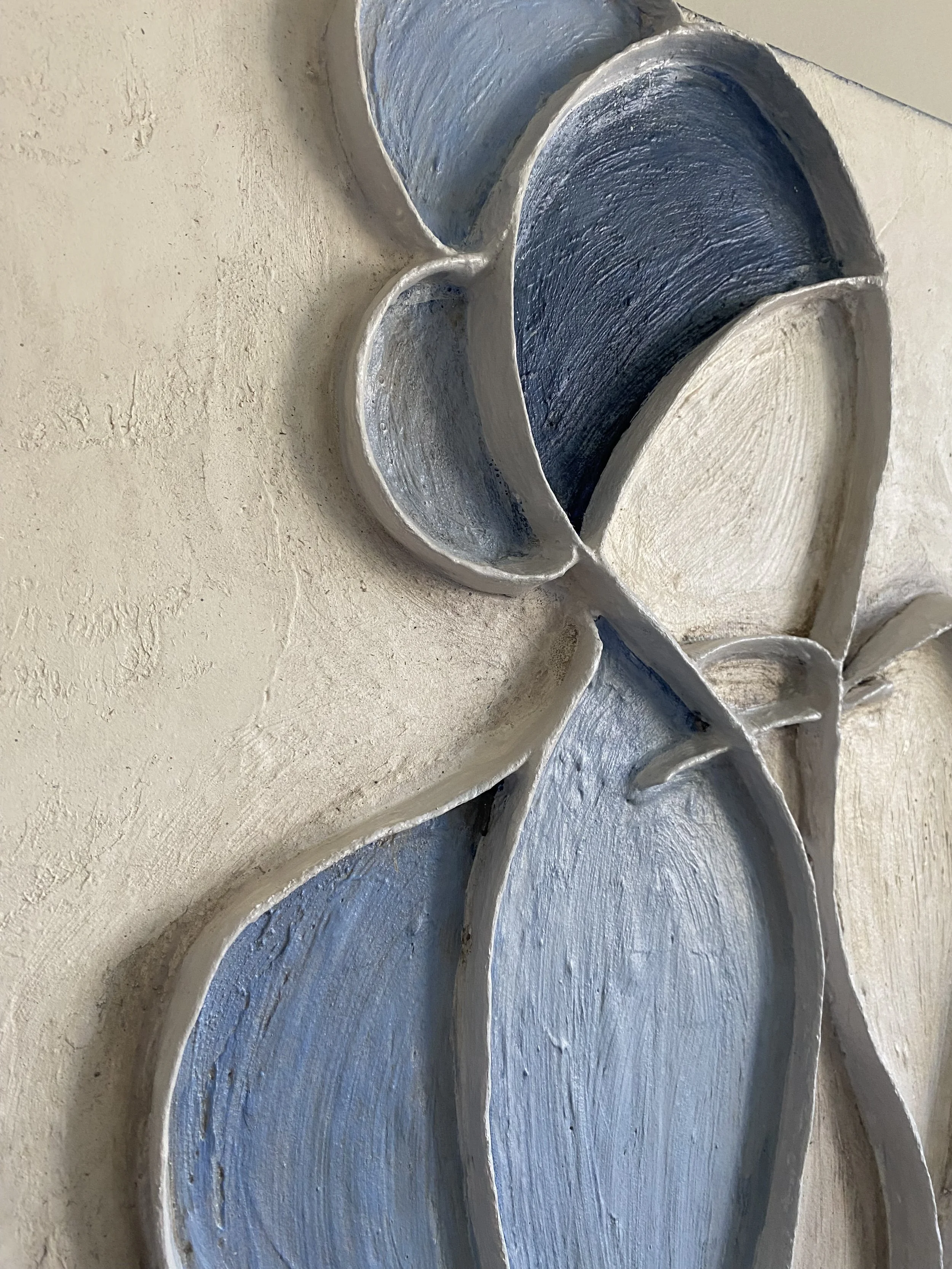 Close-up of a textured blue and white abstract floral wall sculpture