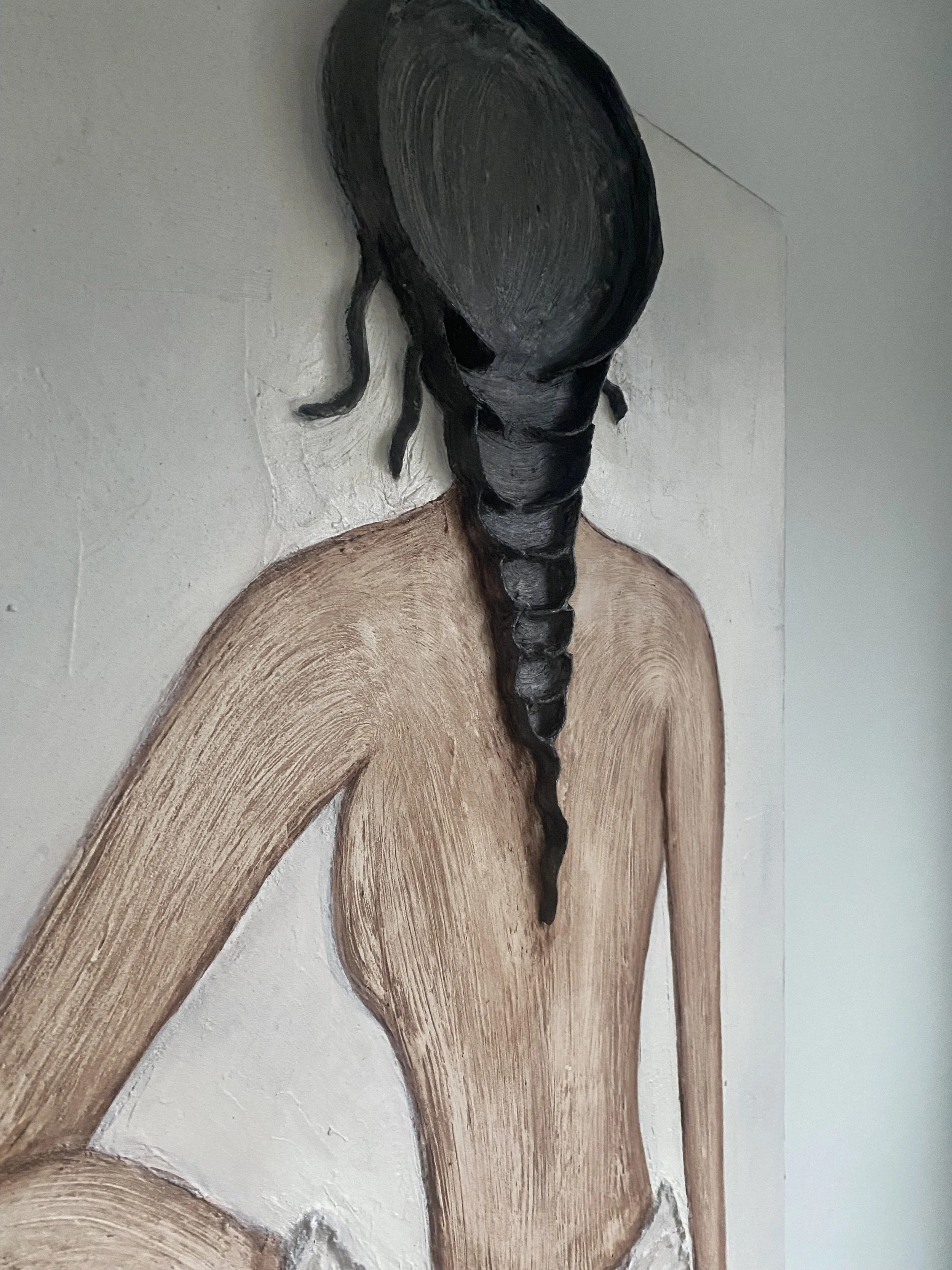 Close-up of a carved wooden seahorse sculpture mounted on a white wall