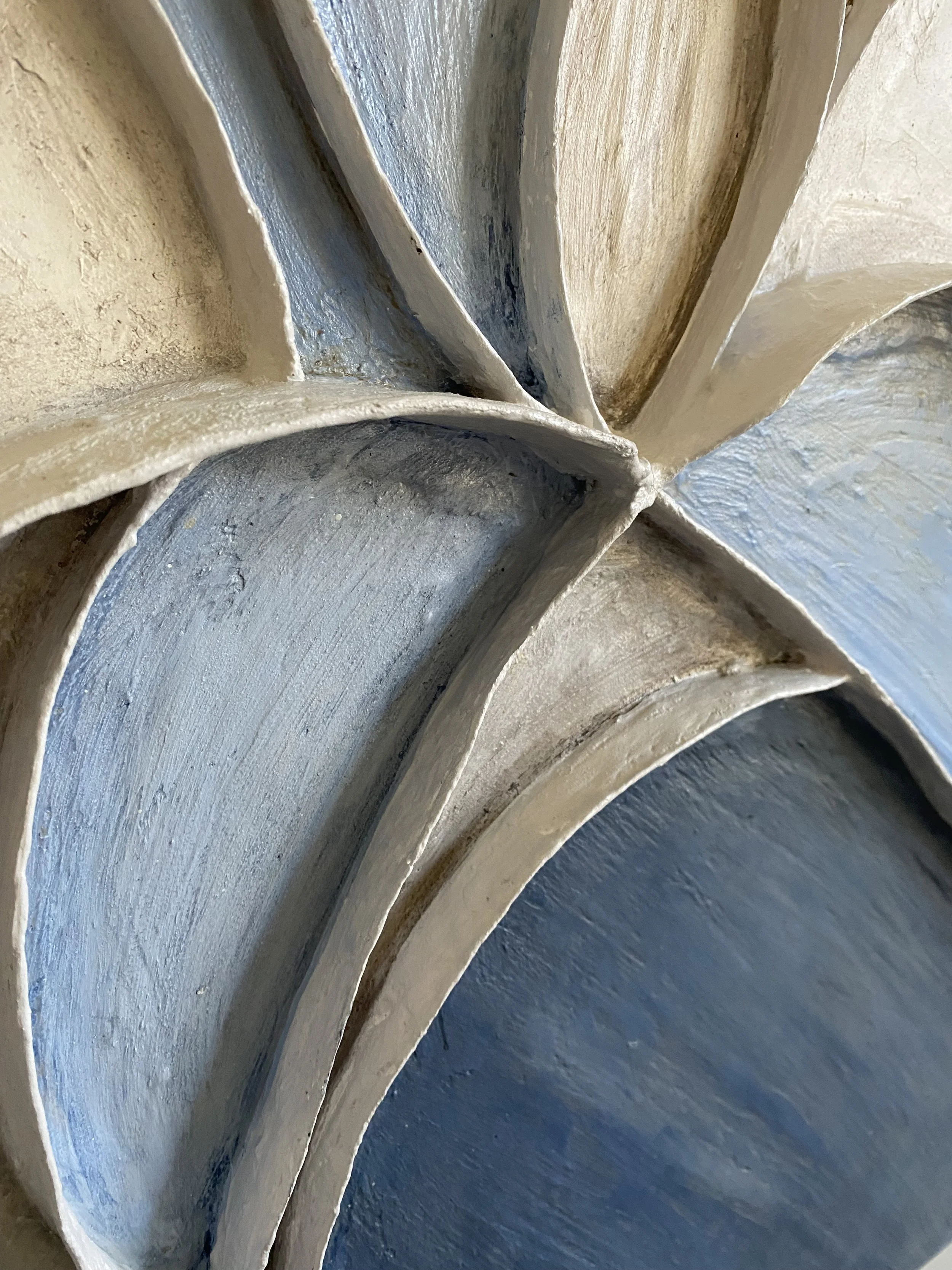 Close-up of weathered blue and cream painted architectural arches with textured surfaces