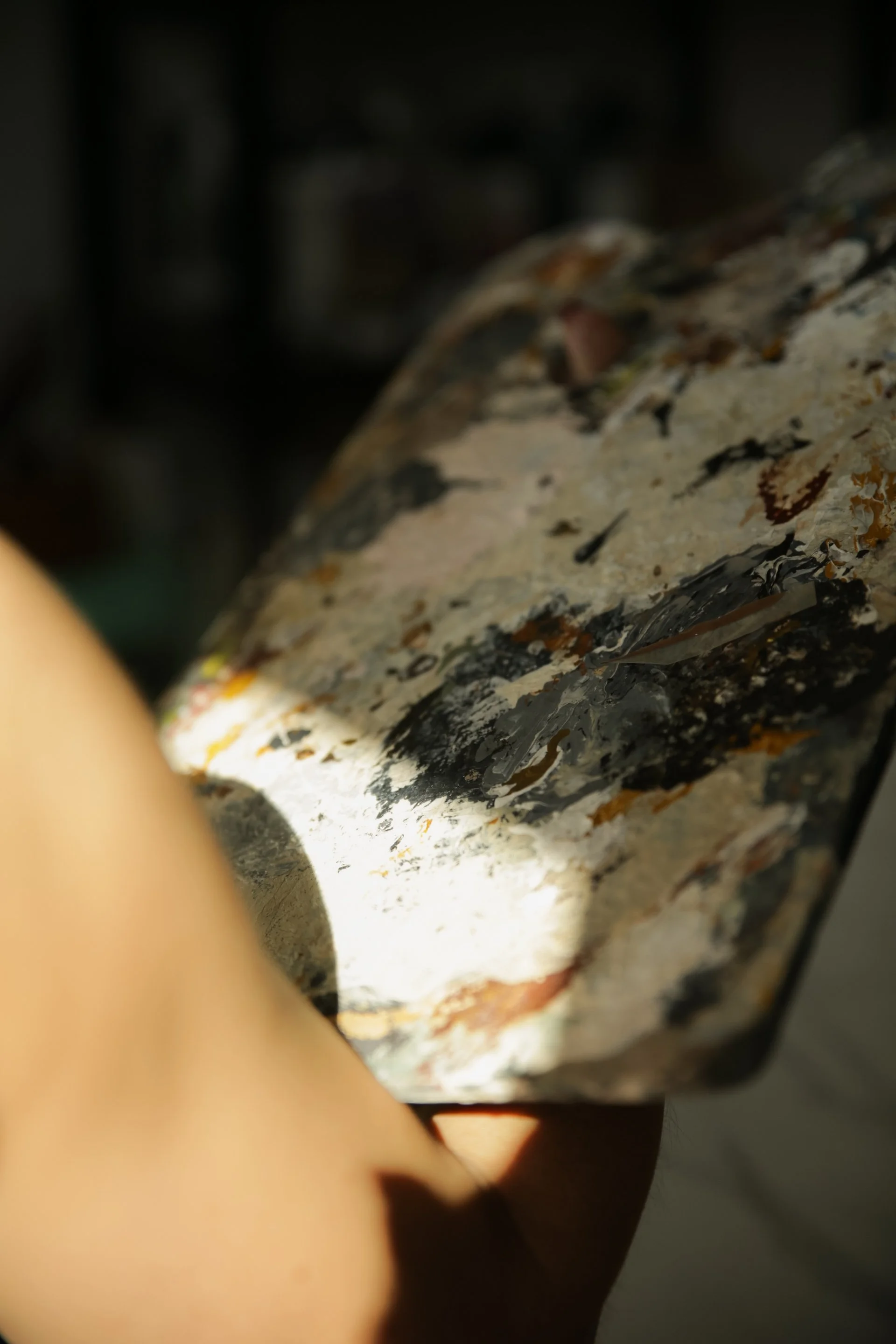 Close-up of a paintbrush loaded with black, white, and brown paint.