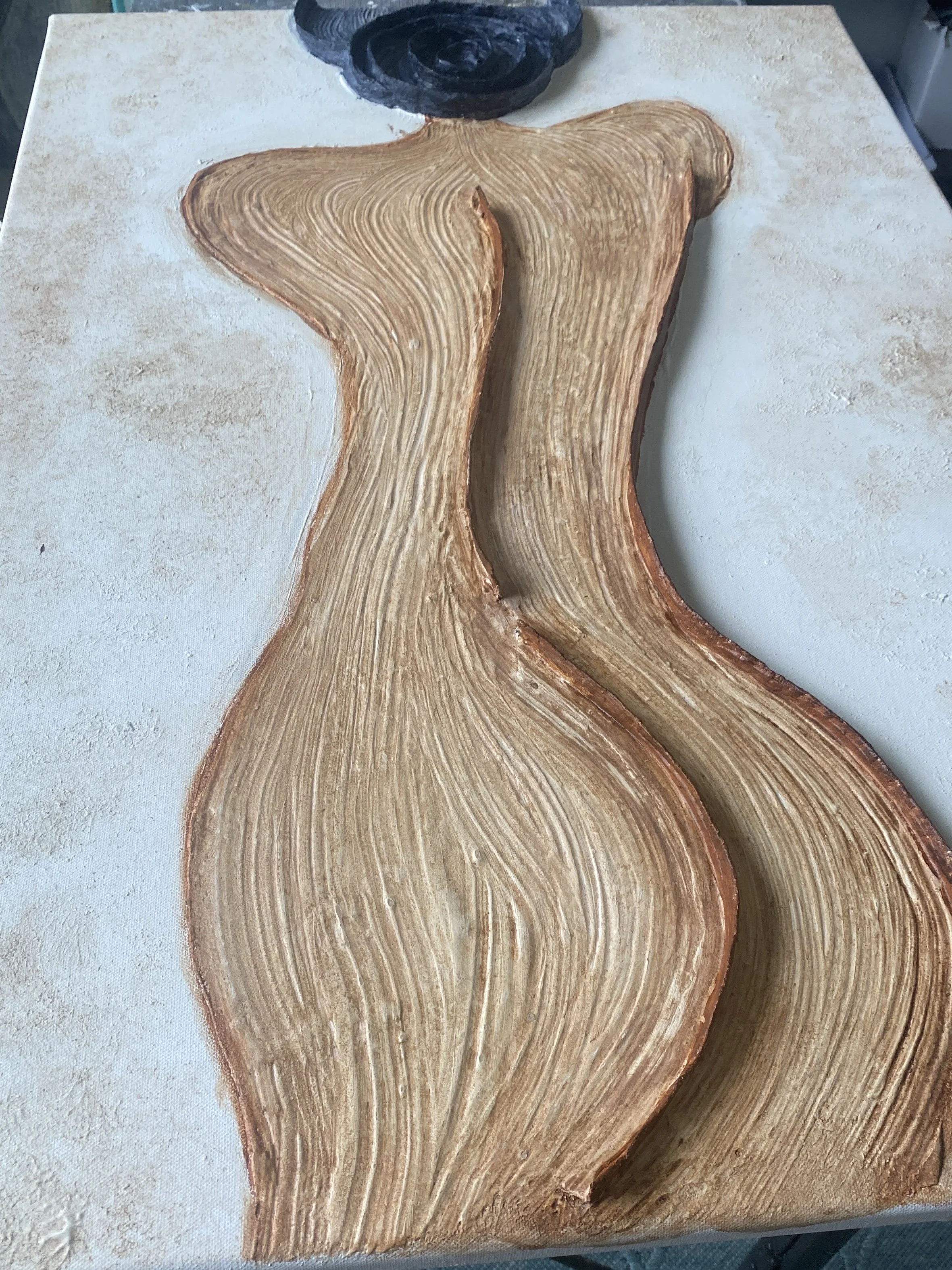 Close-up of a carved wooden mermaid tail sculpture with detailed grain patterns on a workbench