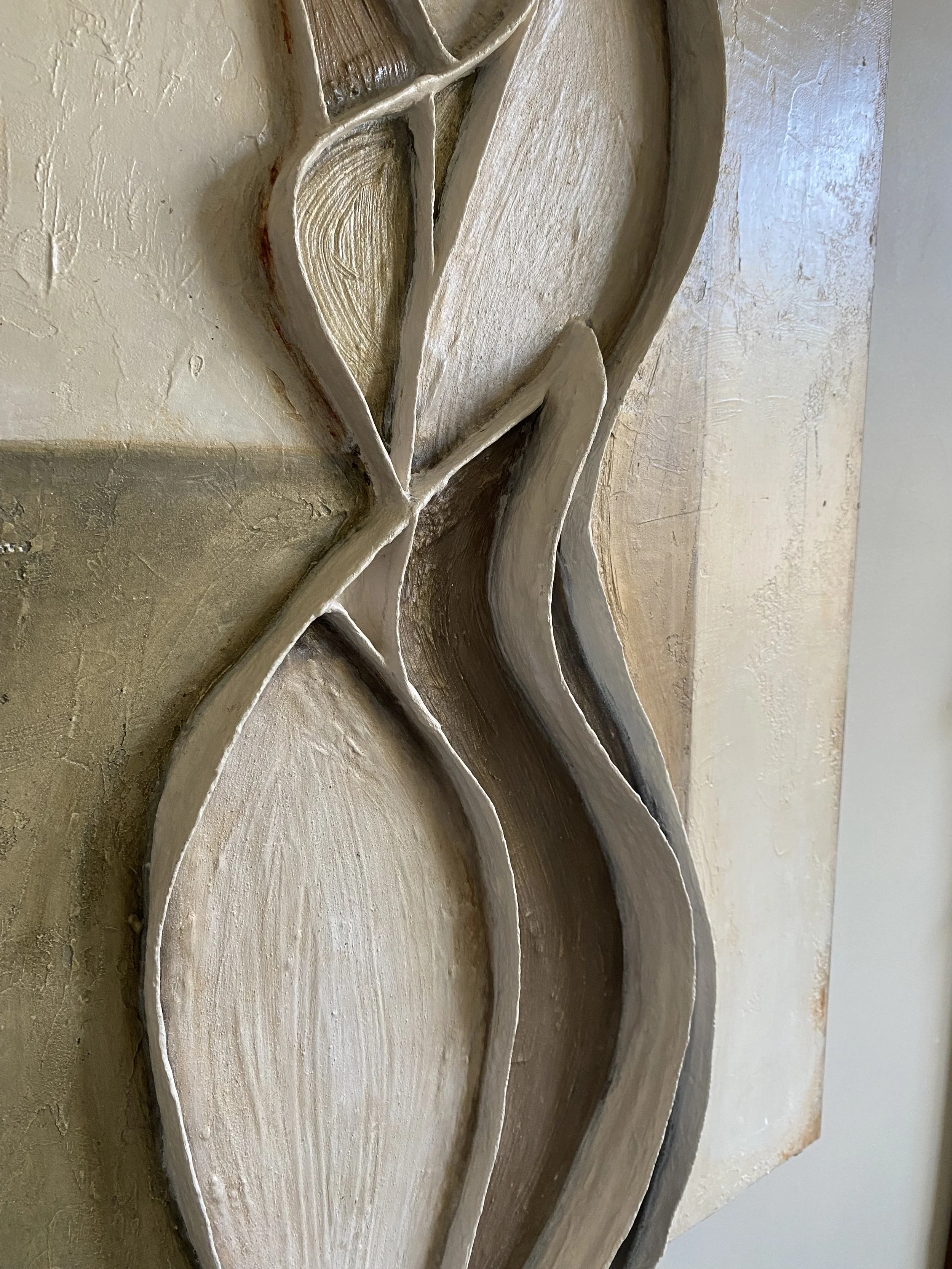 Close-up of a weathered carved wooden floral wall ornament with layered leaves and petals.