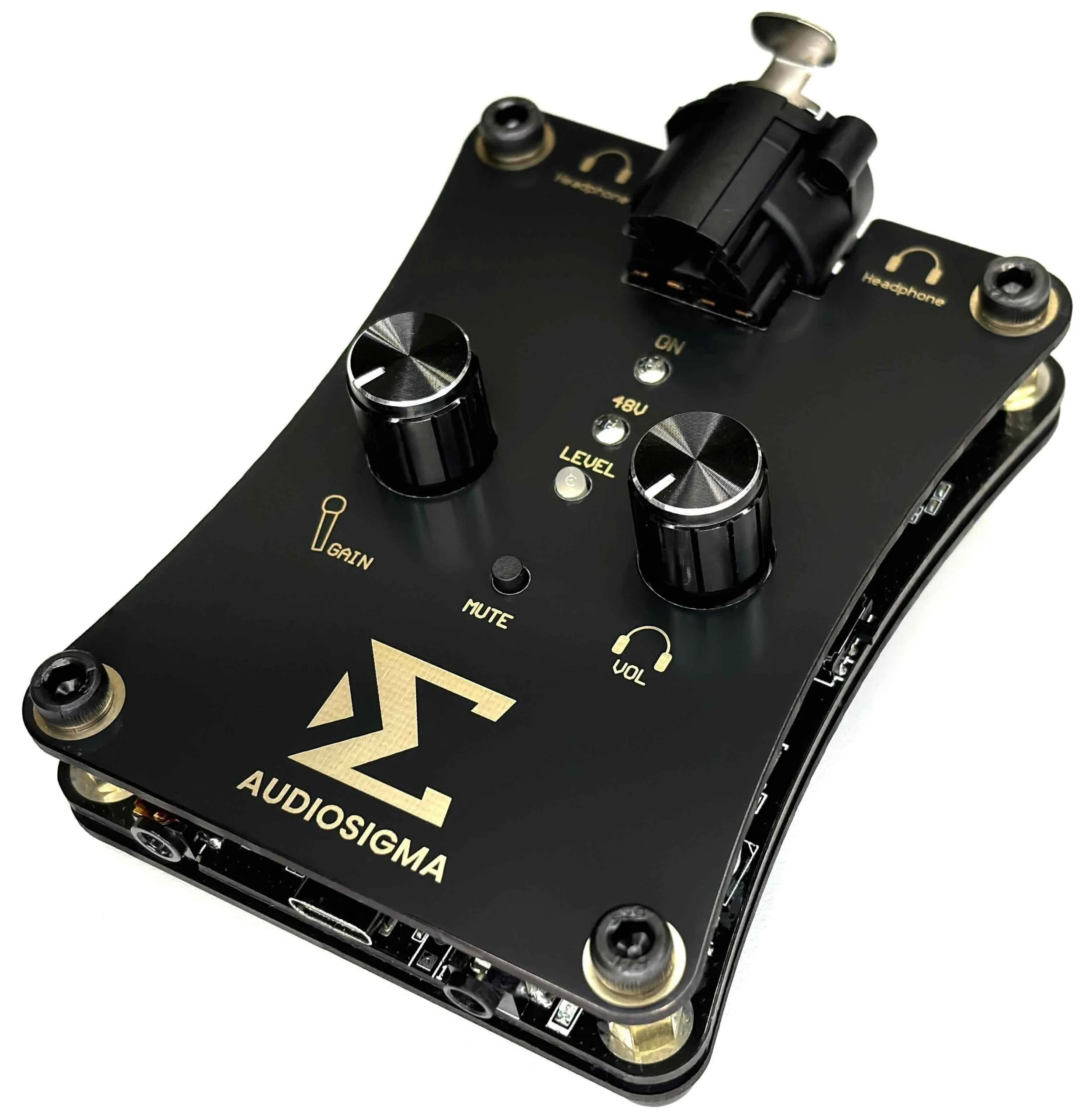 Close-up of a black audio signal processor with knobs labeled 'GAIN', 'LEVEL', 'MUTE', and 'VOL', featuring gold accents and text.