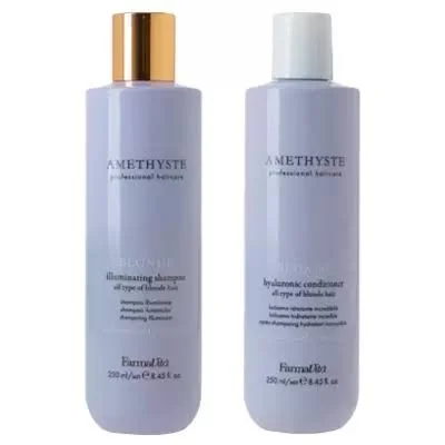 Two bottles of Amethyst professional hair care products, one illuminating shampoo with a gold cap and one strengthening conditioner with a white cap.