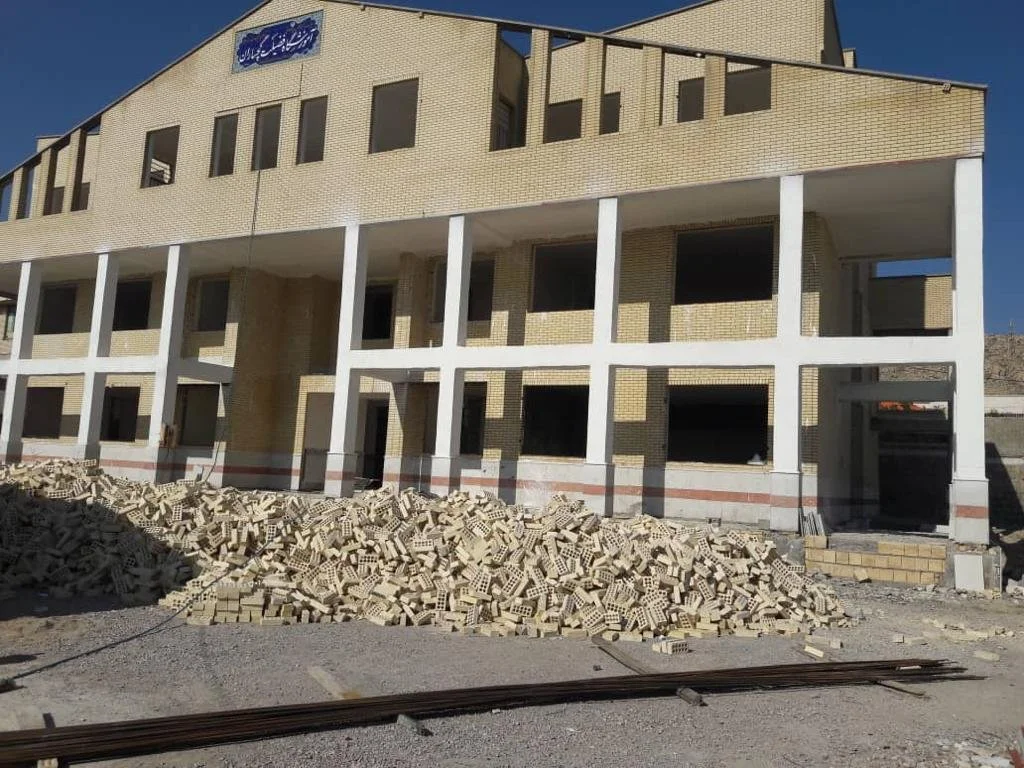 Under construction building with piles of bricks in front.