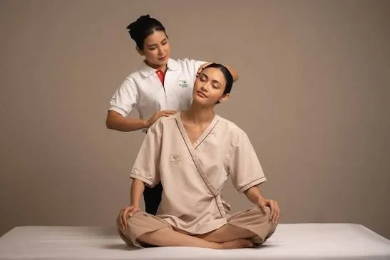 Receiving a seated massage from a professional therapist in a spa or wellness setting.