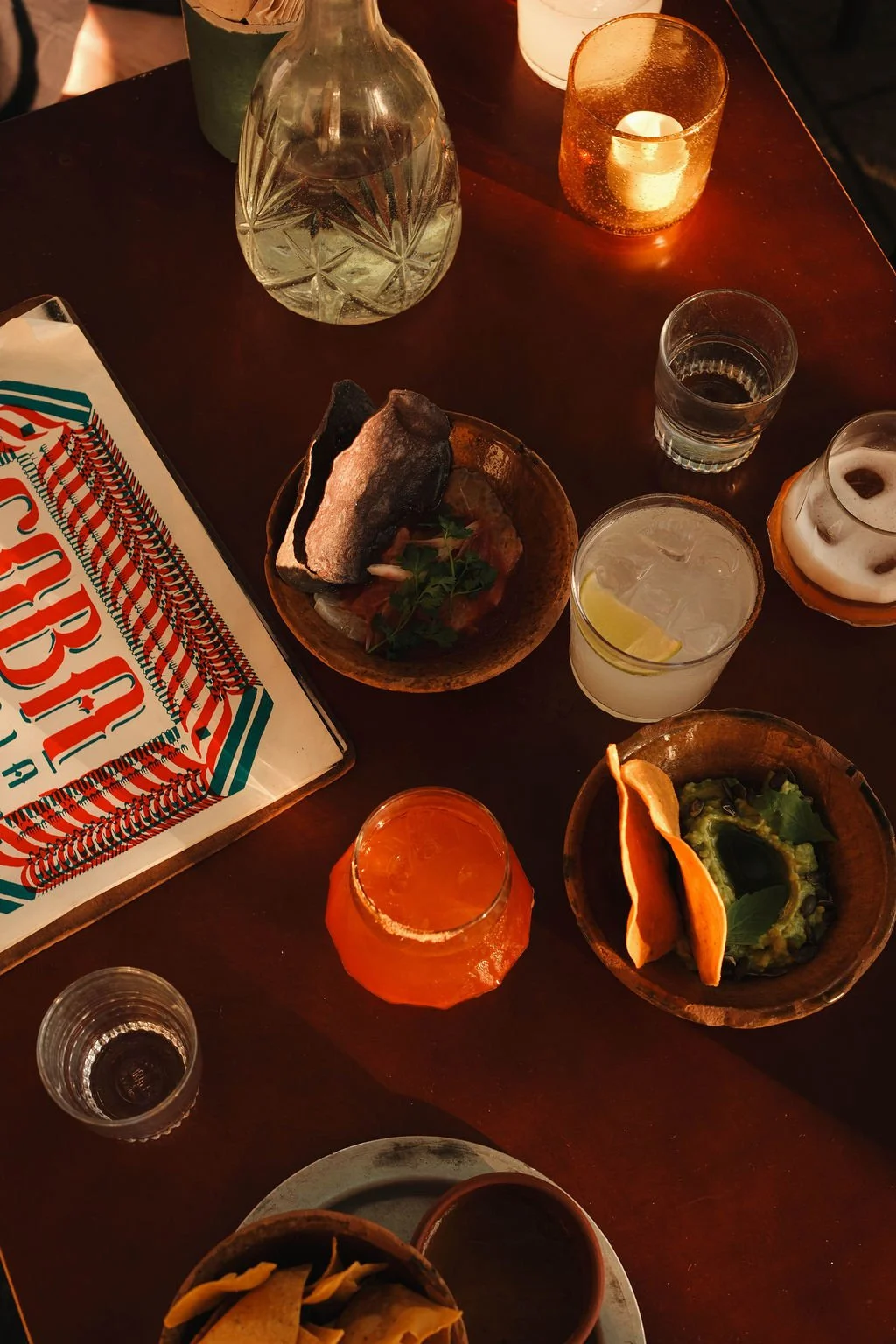Sfeervolle foodfotografie bij COBA Taqueria Amsterdam met een volle tafel vol Mexicaanse gerechten, cocktails en hapjes. Restaurant content door De Eetgency die smaak, sfeer en samen tafelen laat zien en nieuwe gasten aantrekt.