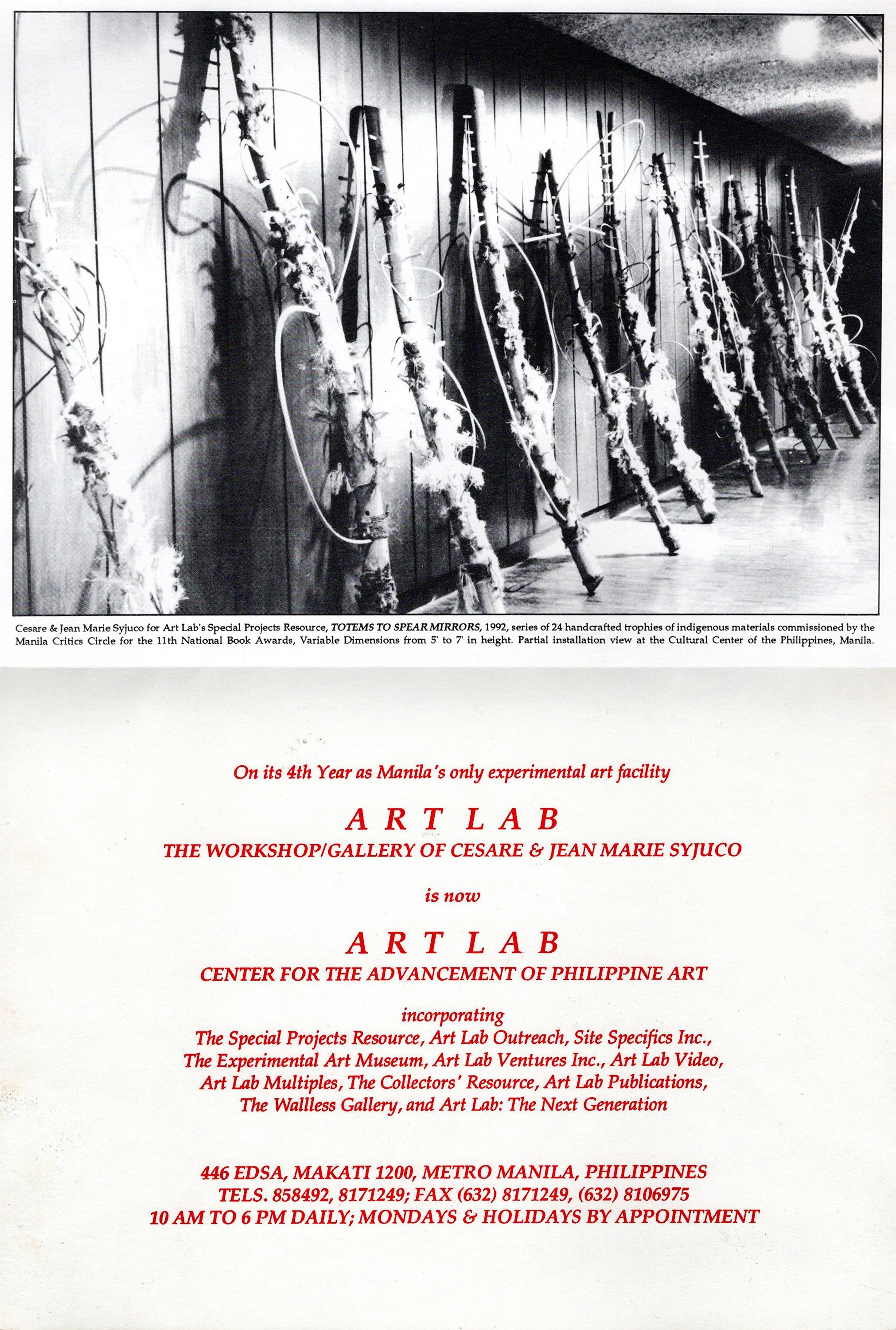 Black and white photograph of an art installation featuring a series of handcrafted trophies resembling rifles or spears, leaning against a wooden wall. Each trophy is decorated with indigenous materials and the installation is part of Cesare and Jea