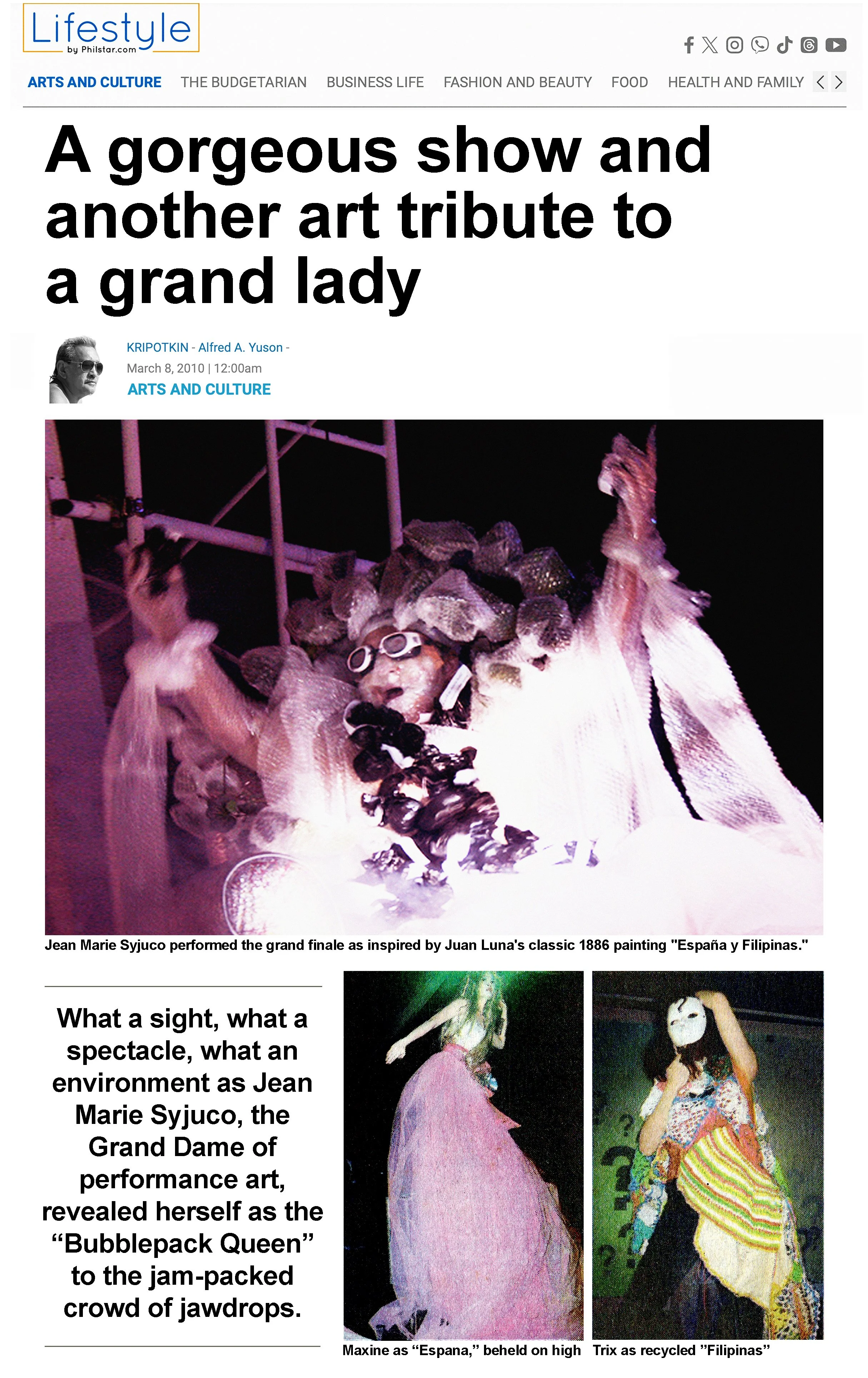 A performer dressed in elaborate costume, including a headdress made of rock-like structures and a white outfit, performing on stage inspired by Juan Luna's painting 'España y Filipinas.'
