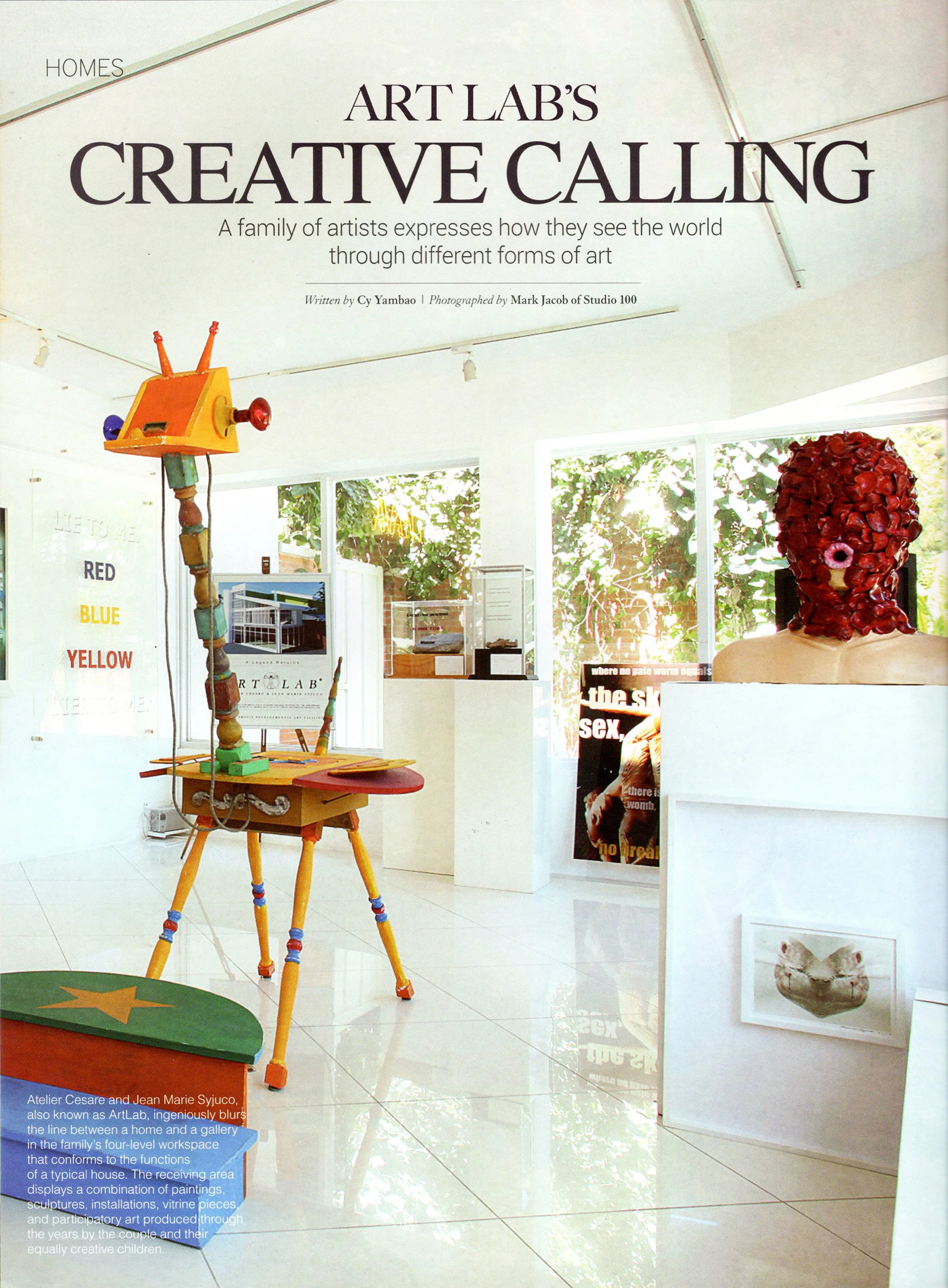 An art exhibit called Art Lab's Creative Calling featuring an eclectic, colorful art installation resembling a robot, displayed in a bright, modern room with large windows and white walls, adorned with paintings and sculptures.