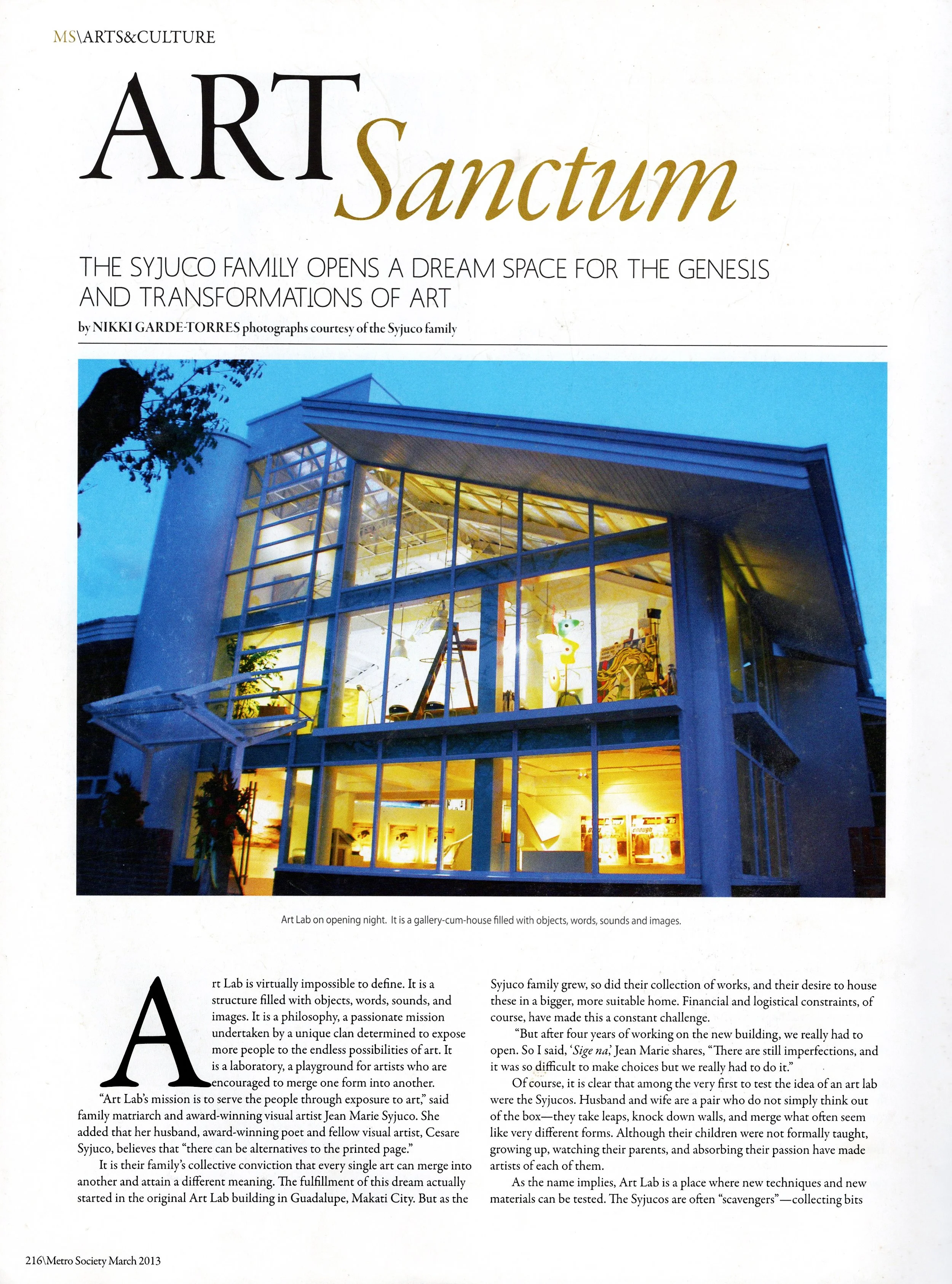 The image shows the cover page of an article or magazine about an art exhibit named "Art Sanctum". The cover features a photograph of a modern building with large glass windows illuminated from within, taken during the evening or night. The headline 