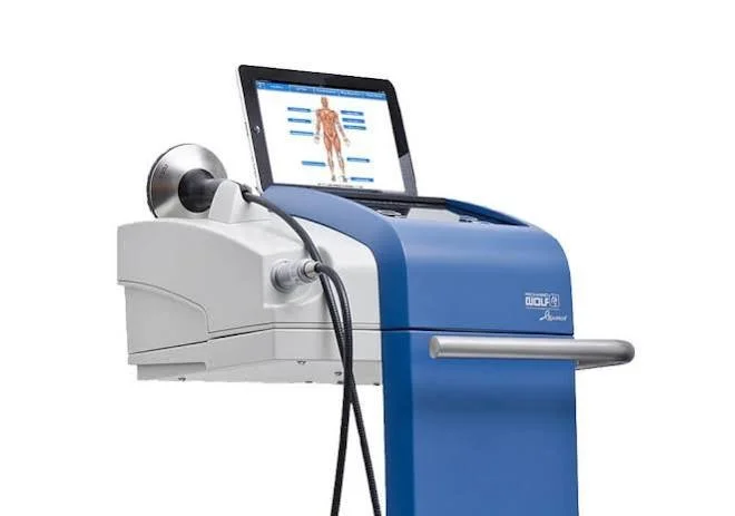 Medical laser device with a monitor displaying a human body diagram and a handheld laser tool attached.
