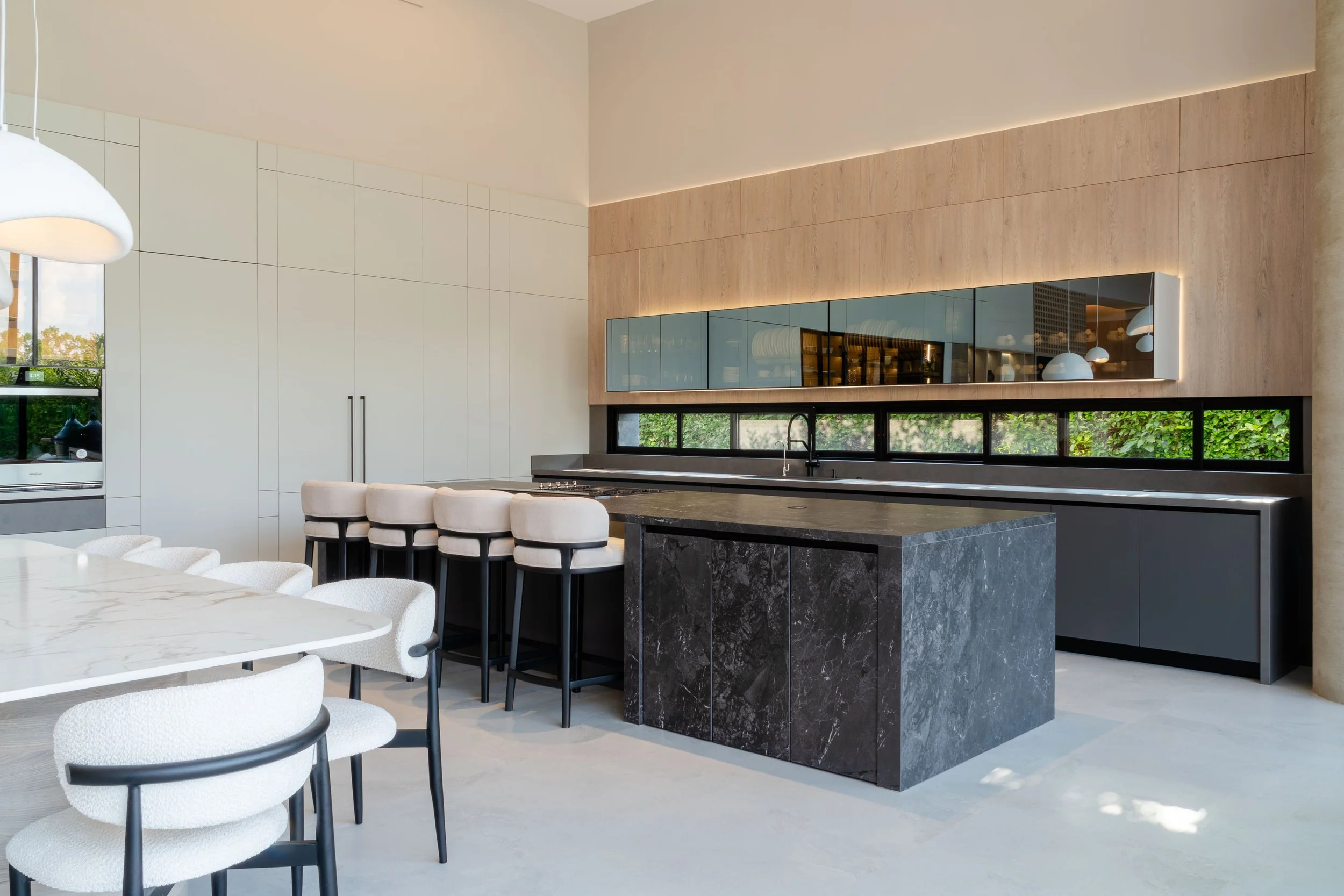 Interiores de cocina moderna con isla de piedra sinterizada, melaminas de calidad premium y herrajes de la mejor tecnología italiana