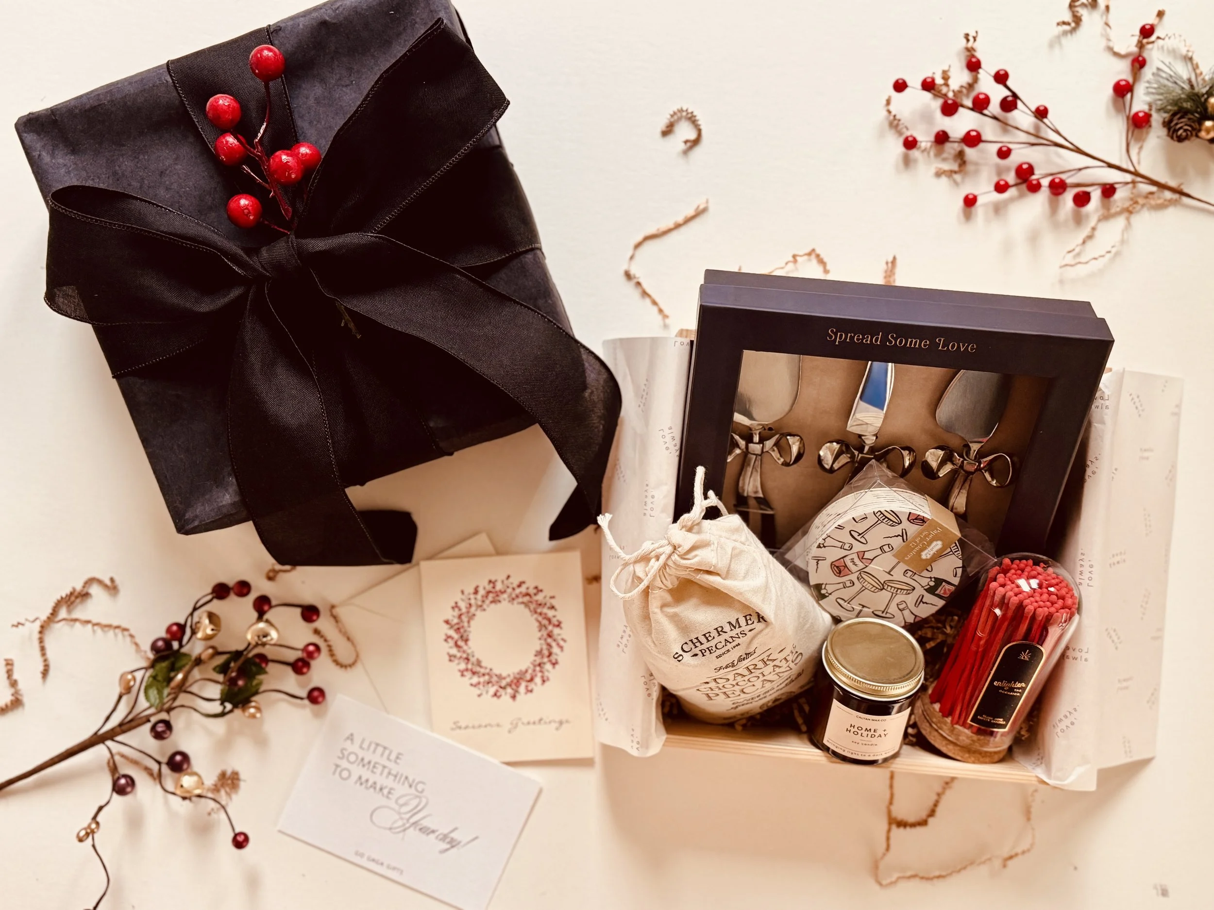 Holiday gift box featuring Home + Holiday mini candle and Schermer Pecans dark chocolate treats