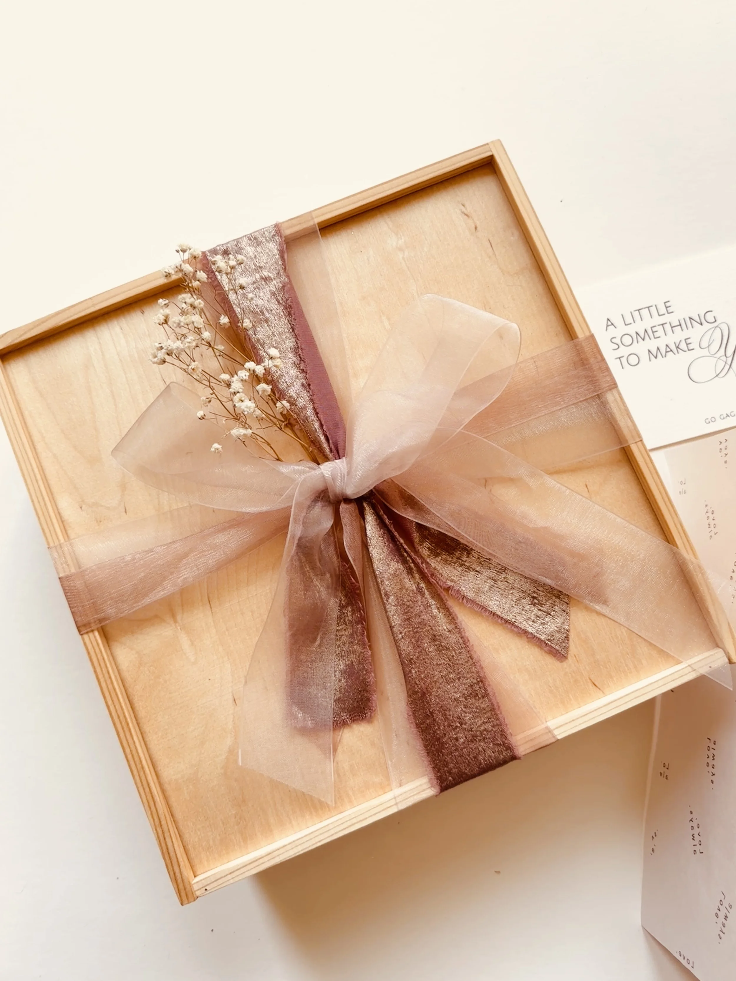 Closed Blush & Bloom Box tied with blush ribbon and dried gypsophila beside a Go Gaga Gifts note card