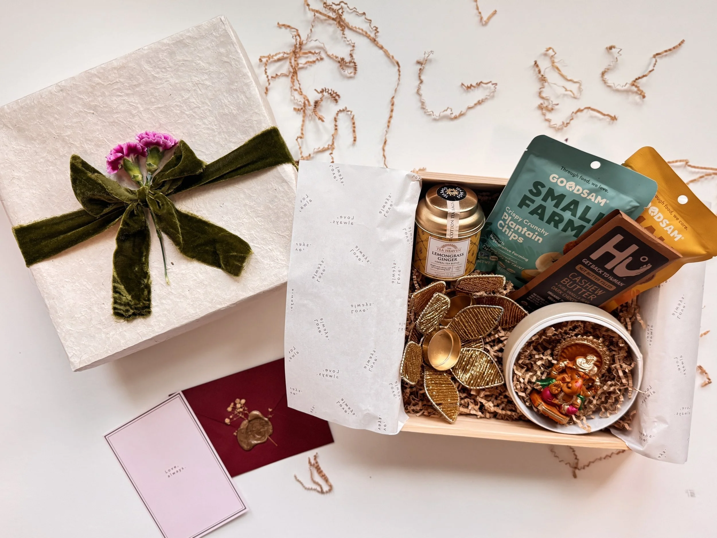 The Gourmet Diwali Box tied with olive velvet ribbon, packed with gourmet tea, plantain chips and chocolate