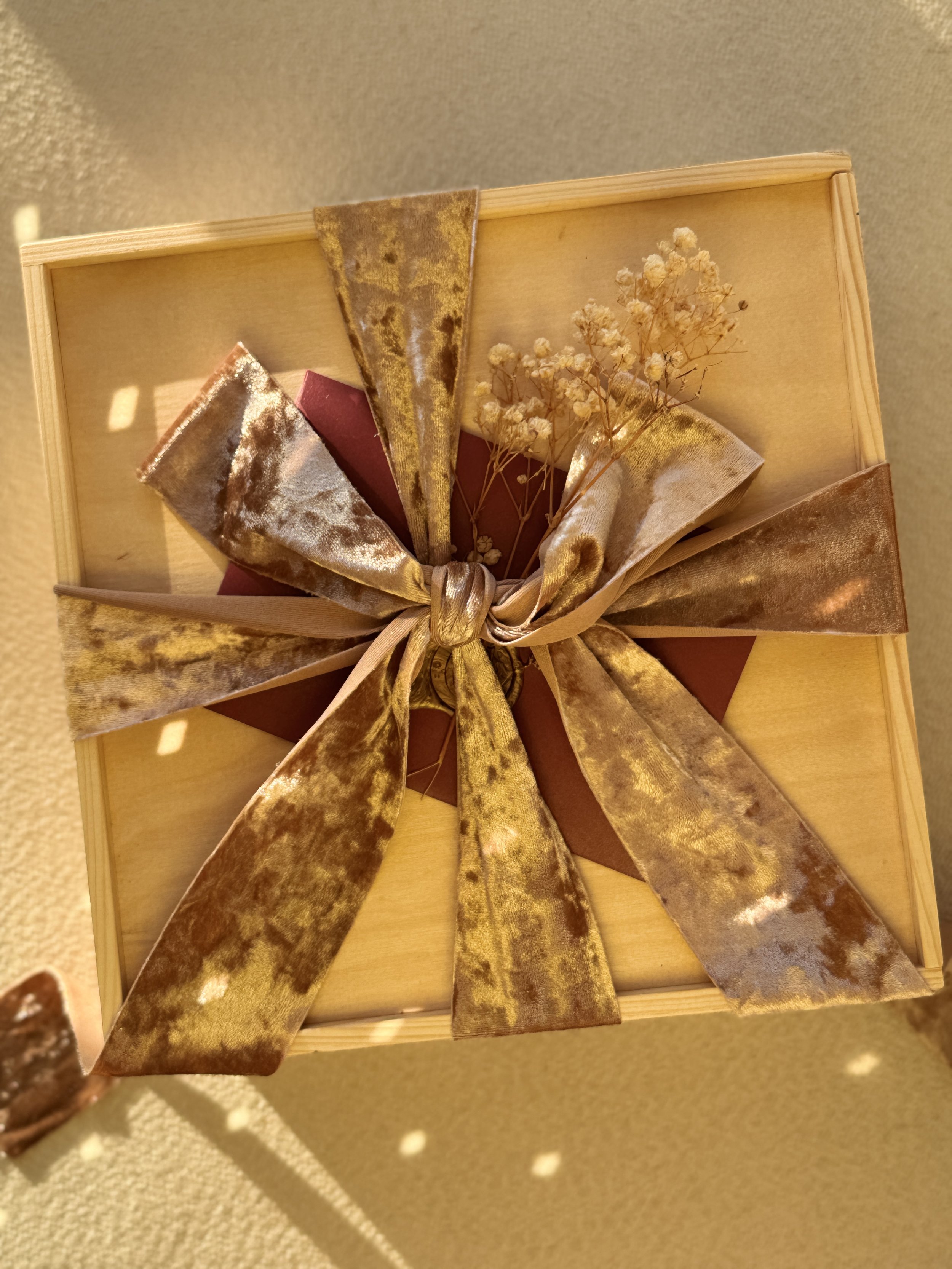 A wooden Go Gaga Gifts box tied with a gold velvet ribbon, wrapped and ready to give