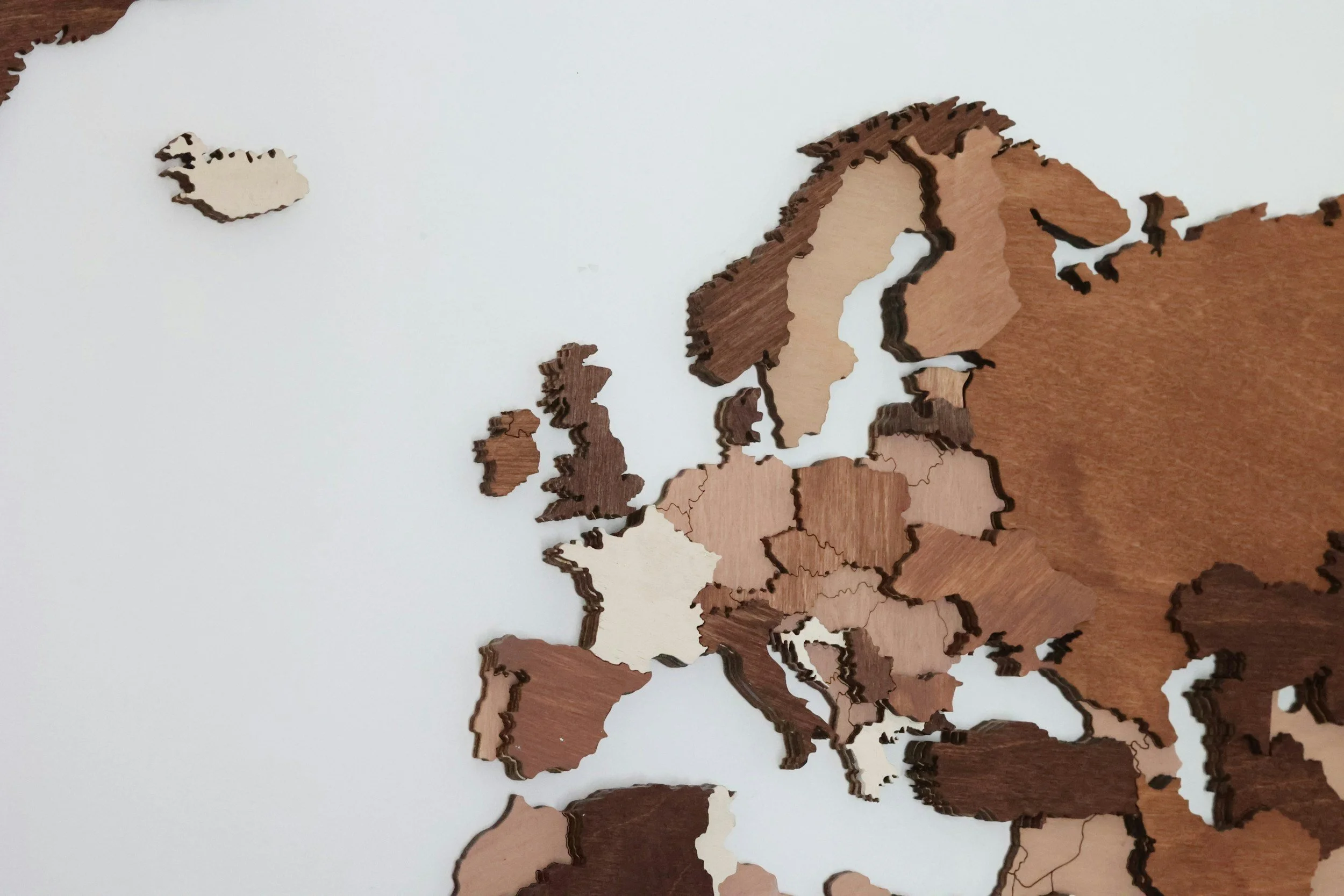 A wooden puzzle map of Europe on a white surface.