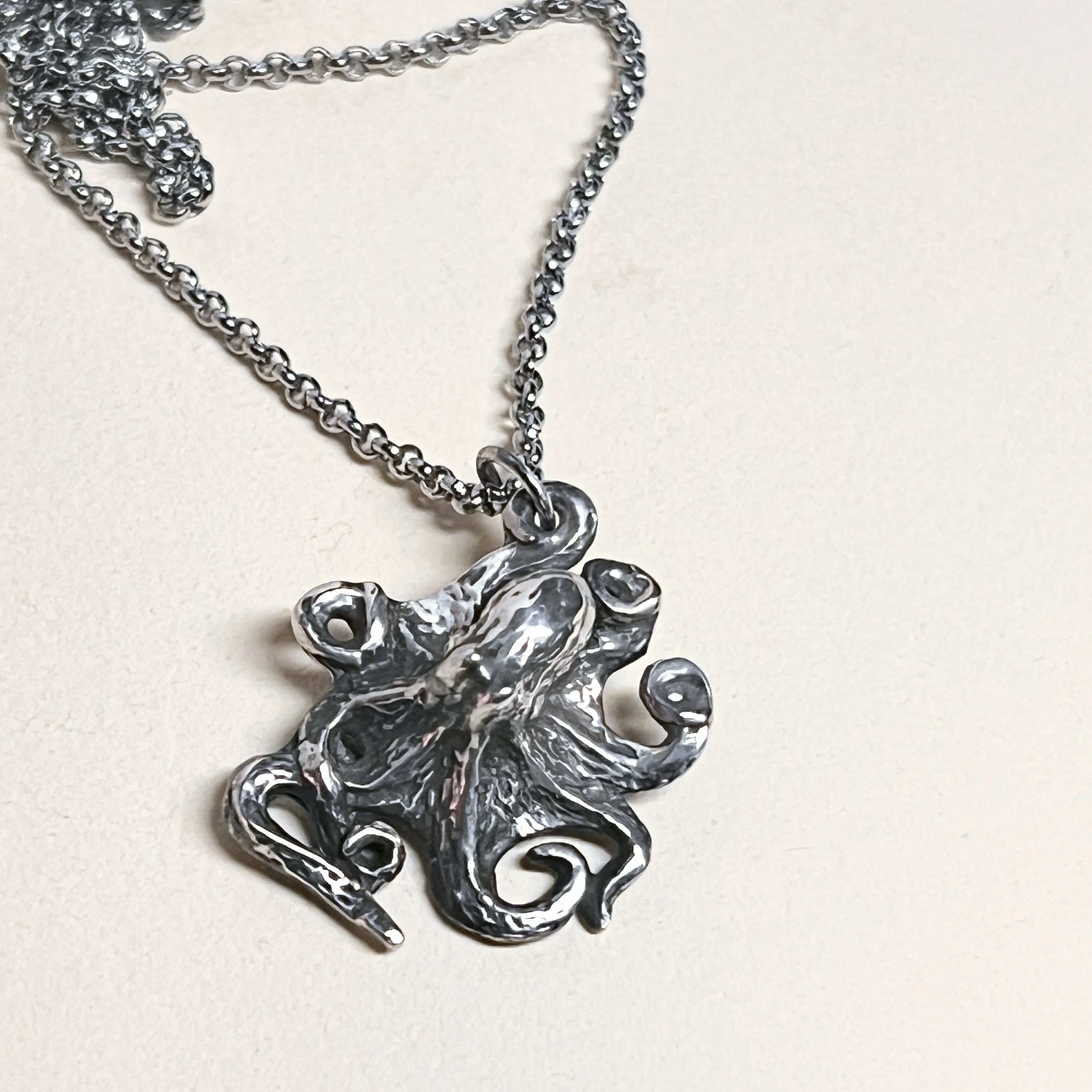 Octopus pendant — oxidized sterling silver on an adjustable stainless steel  cable chain.
Chain 18–20in adjustable · pendant 22x25mm