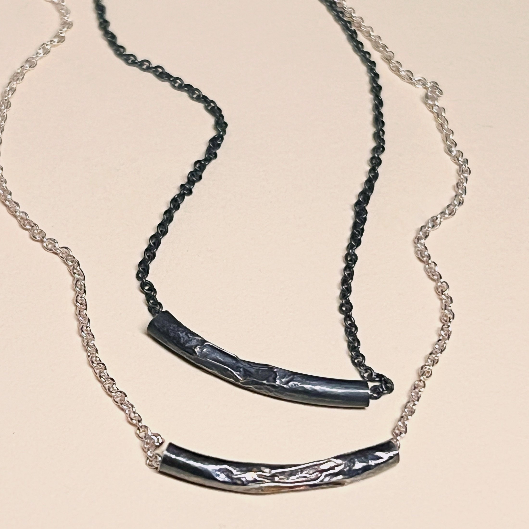 Melted tube necklaces — shown in oxidized and polished sterling silver.
Chain 16in · tube 25mm wide