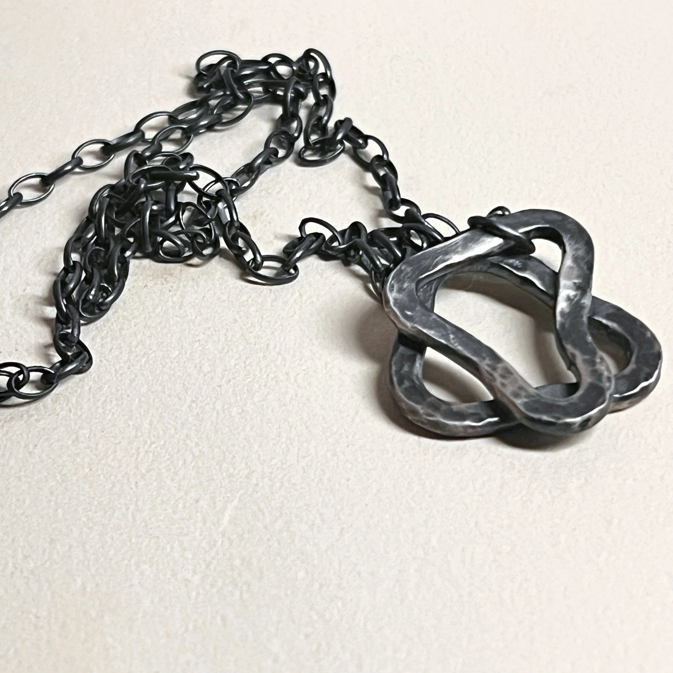 Large star pendant — abstract star in oxidized sterling silver on a cable chain.
Chain 24in · pendant 28x28mm