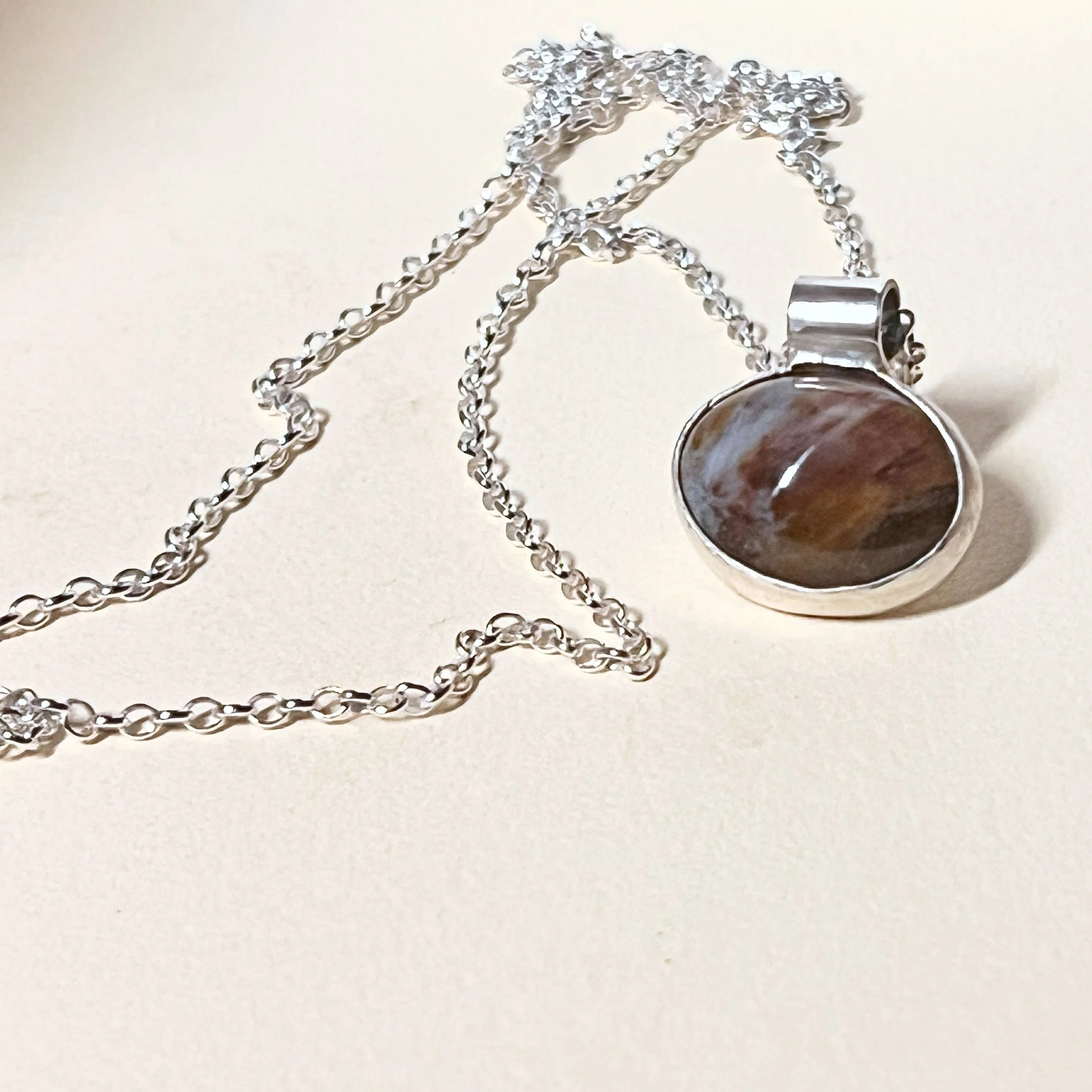 Pendant — pietersite cabochon on a long sterling silver cable chain.
Chain 24in · pendant 13x20mm