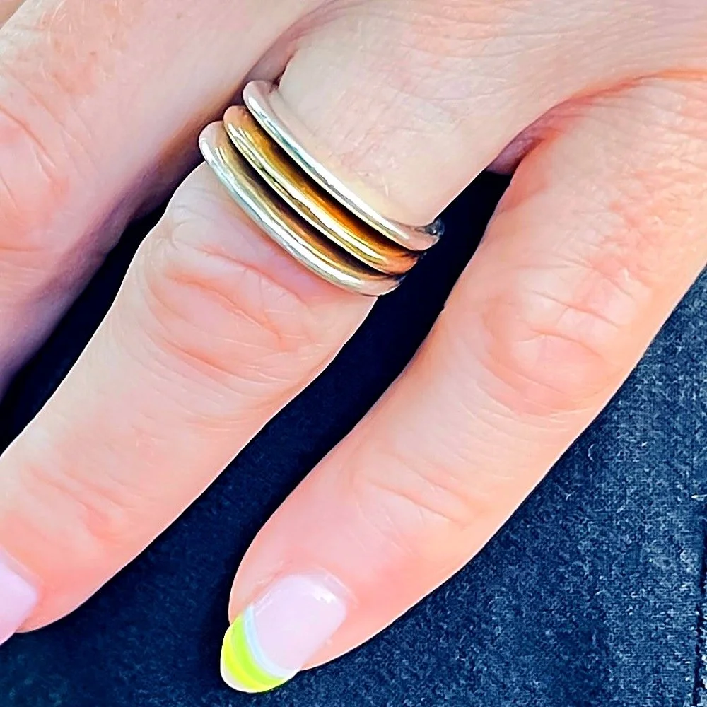 Megan, wearing the stacking rings in gold, silver and brass