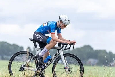 A cyclist riding a bike in an open field during daytime.