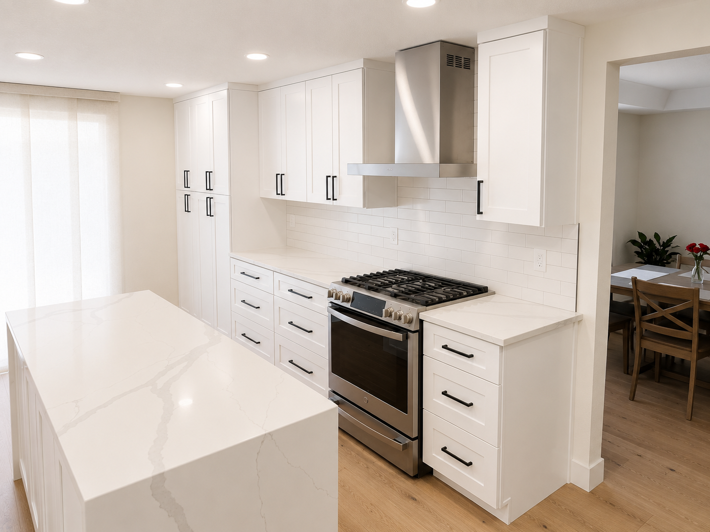 Modern kitchen with white cabinets, marble countertop island, stainless steel gas stove, stainless steel range hood, white subway tile backsplash, and hardwood floors.