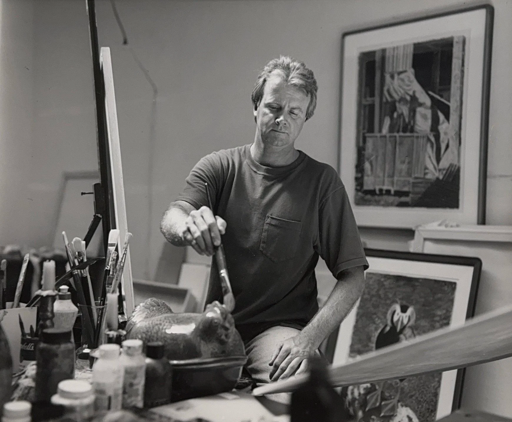 Honoring George G Woodall. George Woodall is sitting on a stool with paintbrush in his right hand painting "Angel on My Nose" in the Woodall Studio Gallery, a gallery in downtown Seattle across the street from the Seattle Art Museum (SAM)
