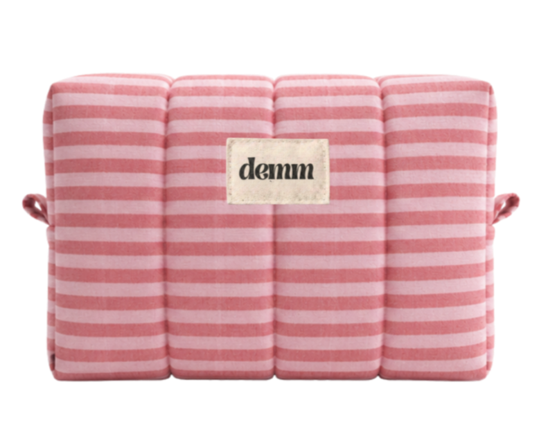 A handmade pink striped quilted make up bag with the brand name 'DEMM'.
