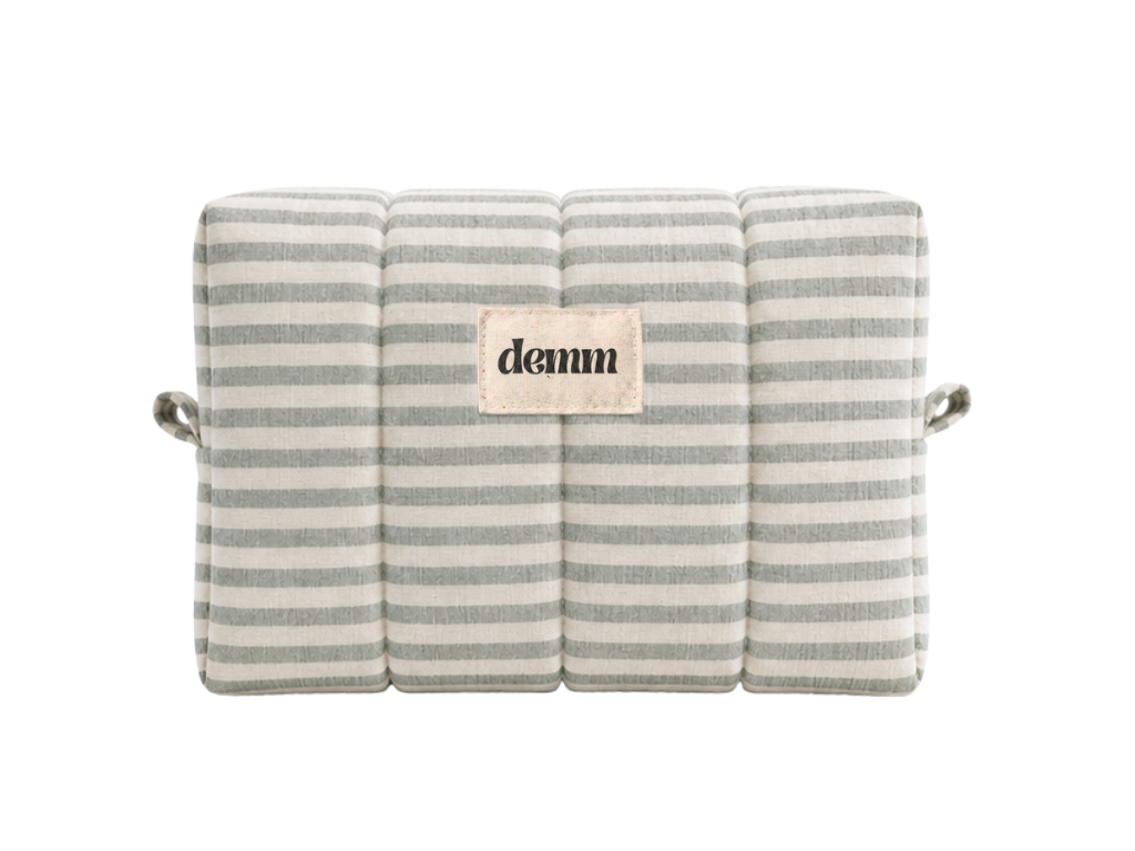 A handmade green striped quilted make up bag with the brand name 'DEMM'.