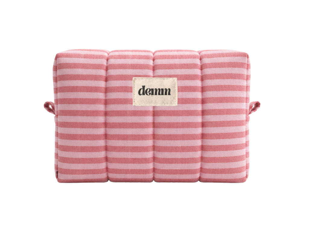 A handmade pink striped quilted make up bag with the brand name 'DEMM'.